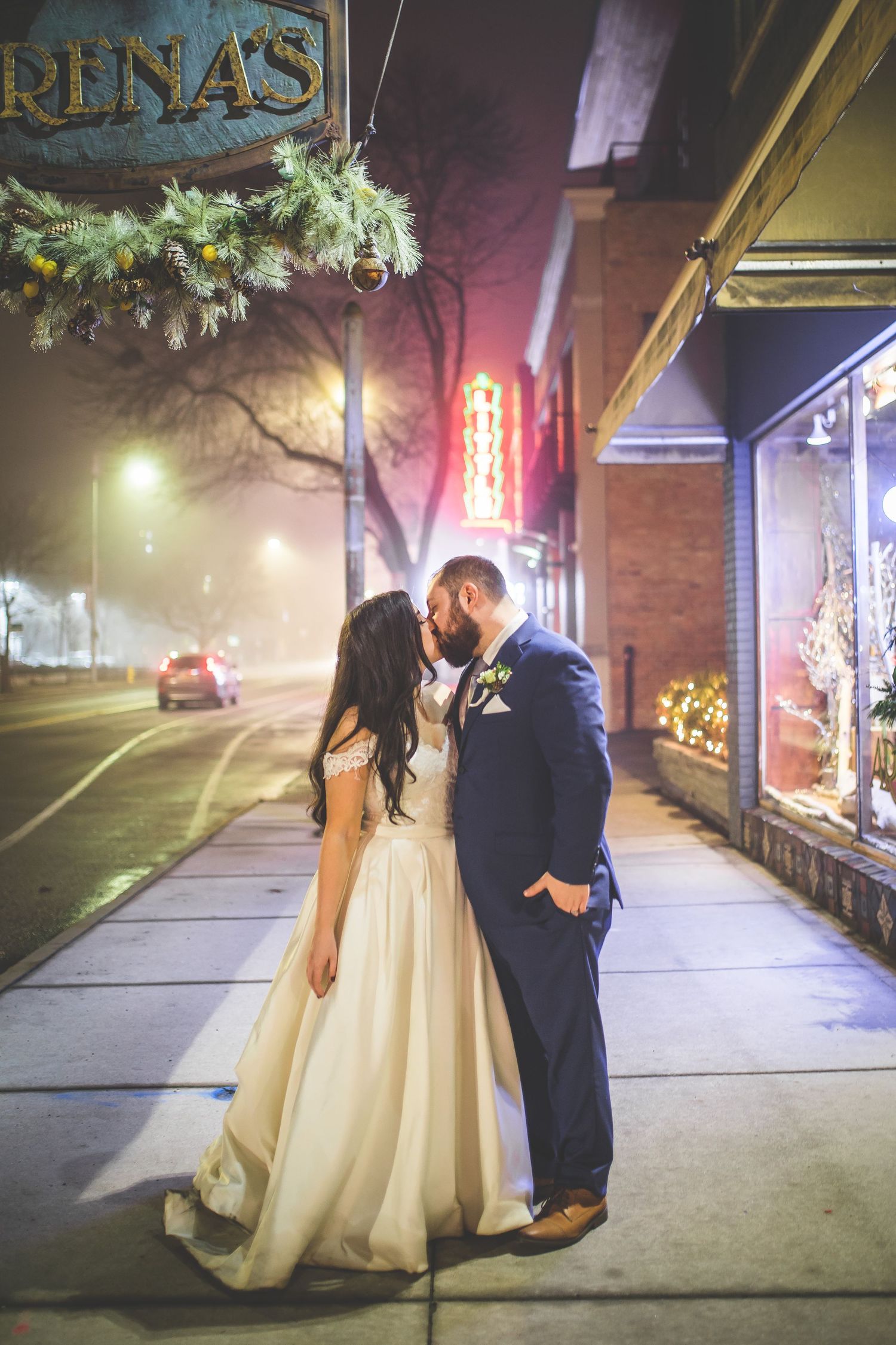 Romantic nighttime street scene with illuminated storefront and neon signs.
