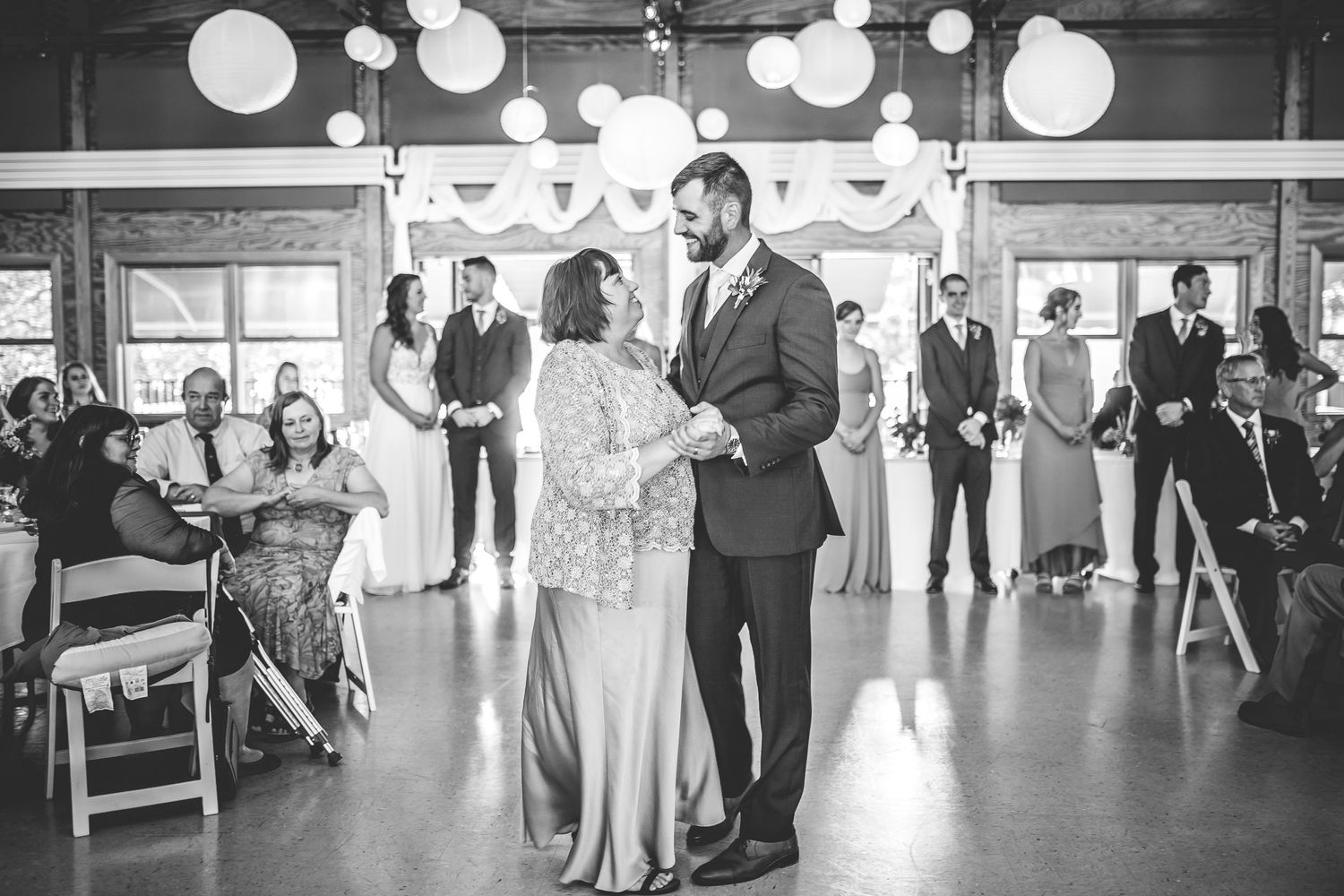 Wedding reception venue decorated with white paper lanterns and string lights creating a romantic atmosphere.