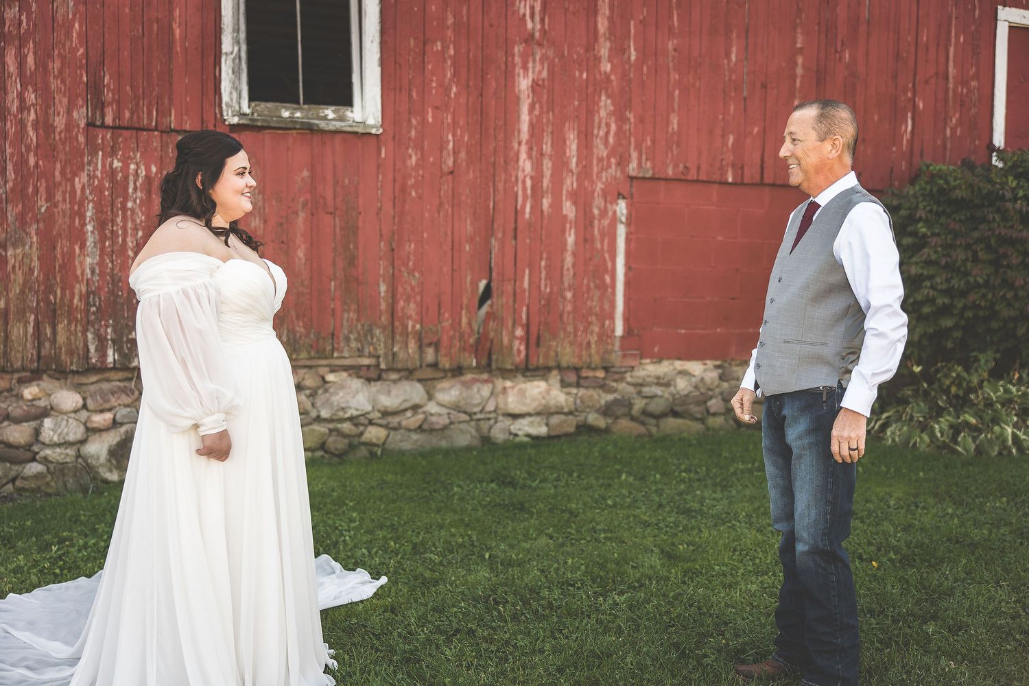 Wedding celebration candid moments captured outside a vintage red barn.