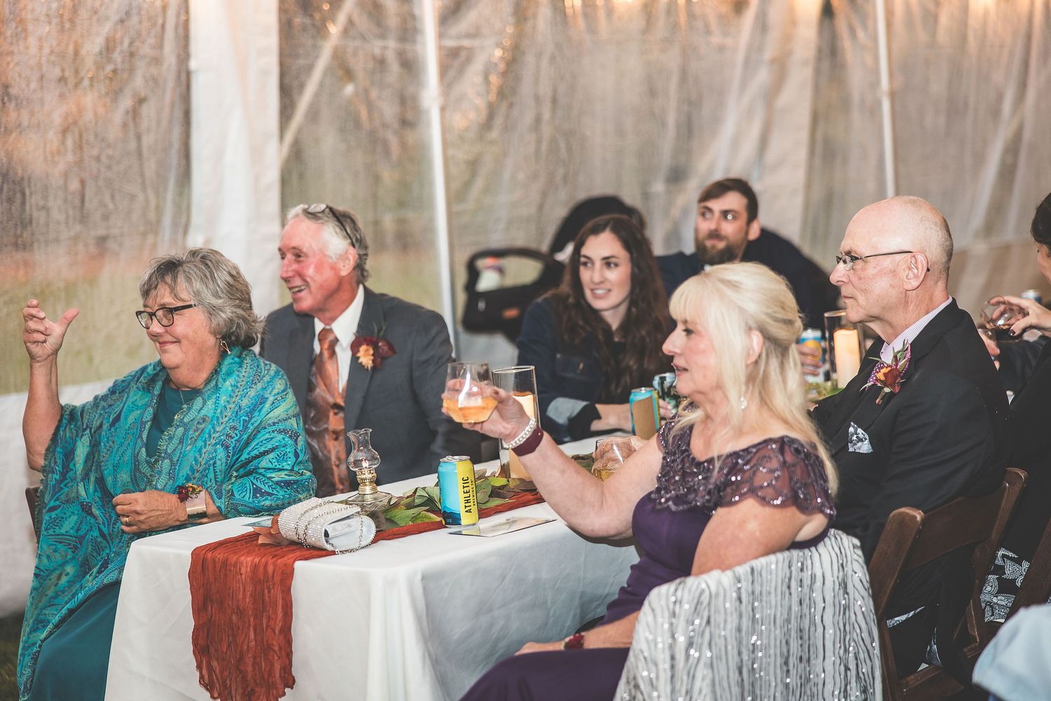 Wedding reception guests seated at tables enjoying dinner under string lights.