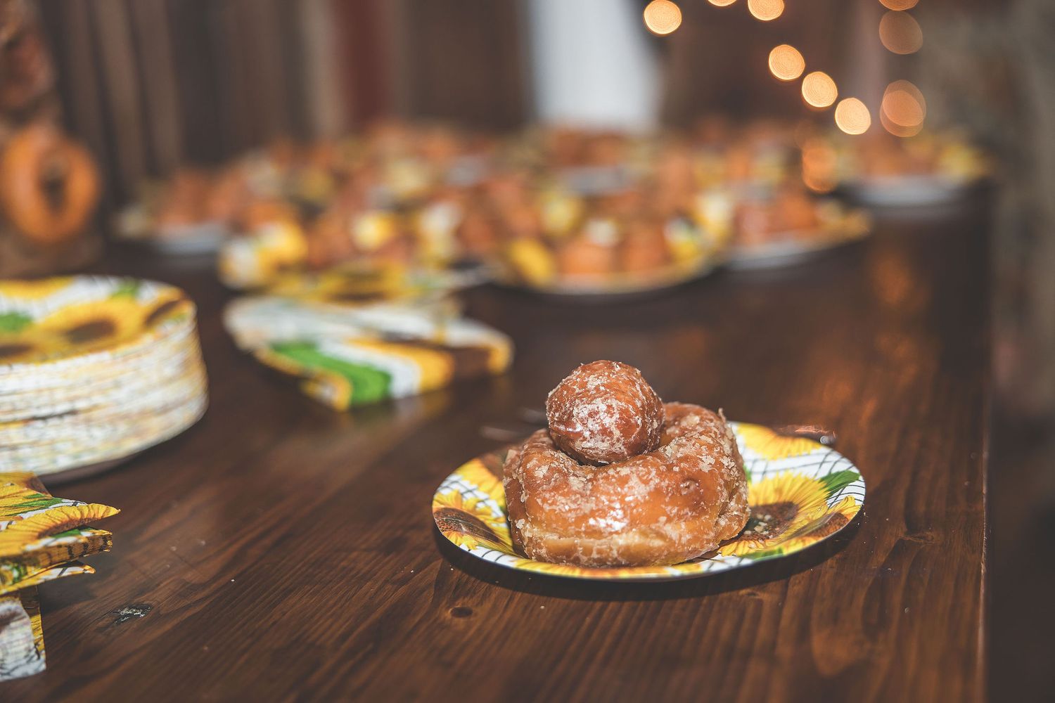 Close-up of chocolate glazed donuts served on decorative plates at wedding reception.