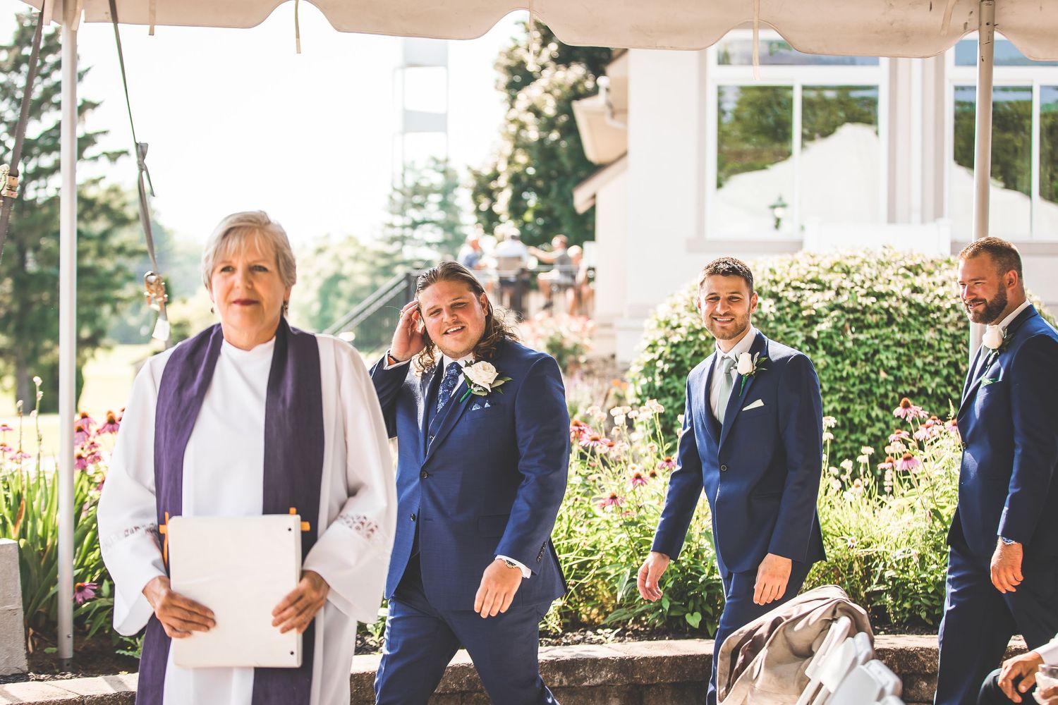 Wedding ceremony setup outdoors with guests seated under sunny skies.