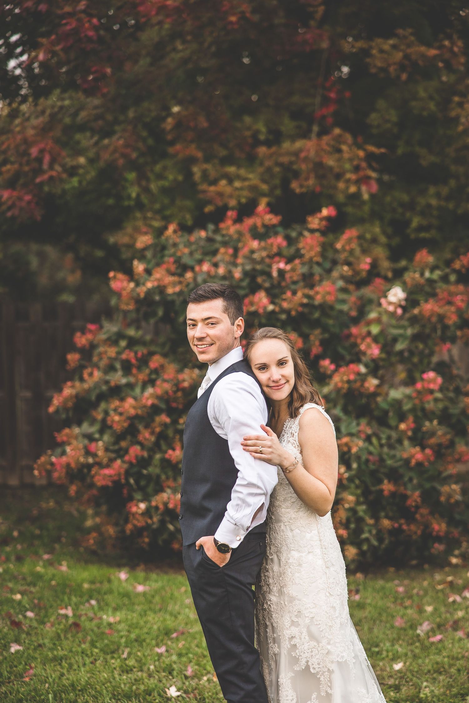 Autumn wedding portrait with colorful fall foliage and formal attire.
