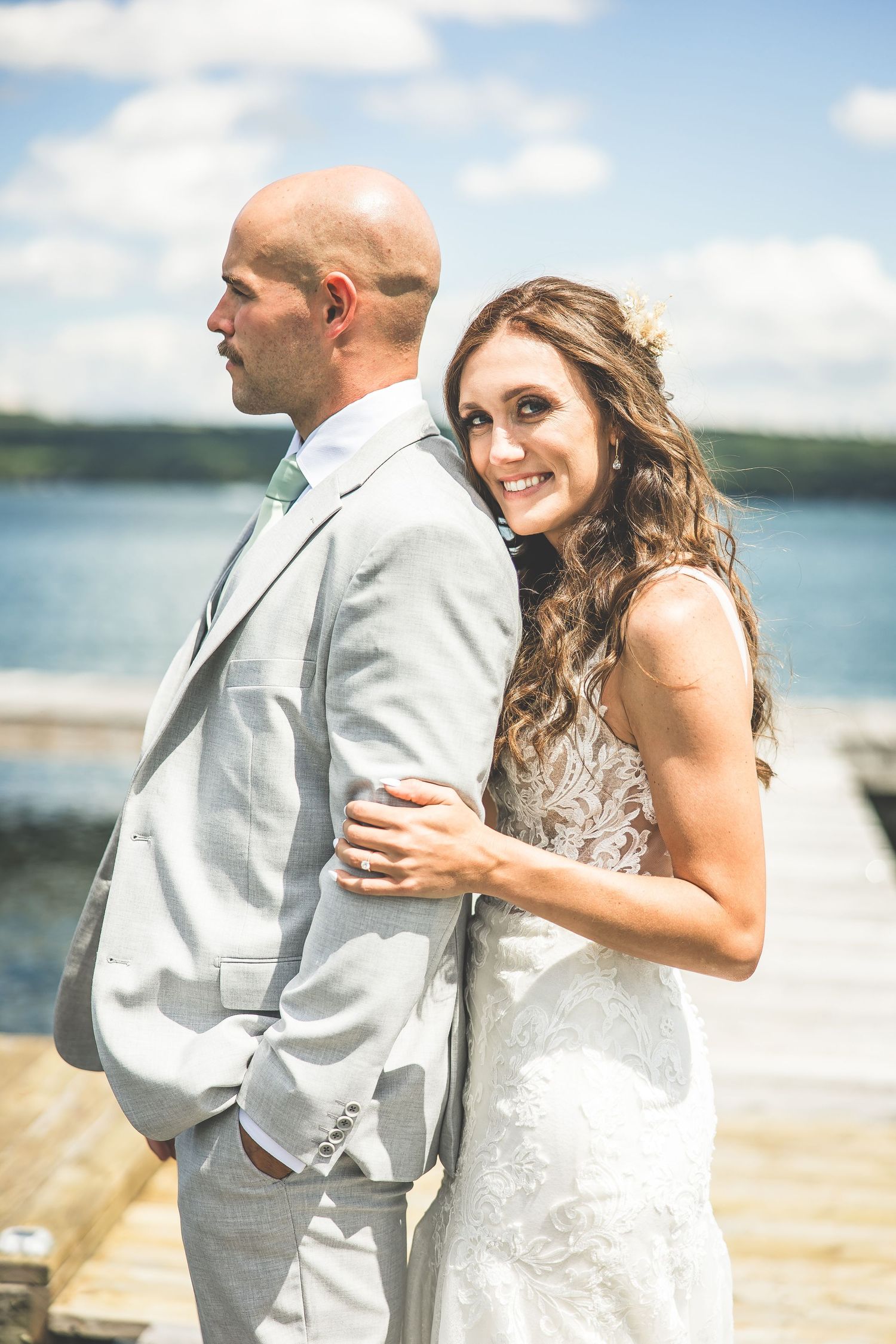 A couple shares their first look moment during a lakeside wedding.
