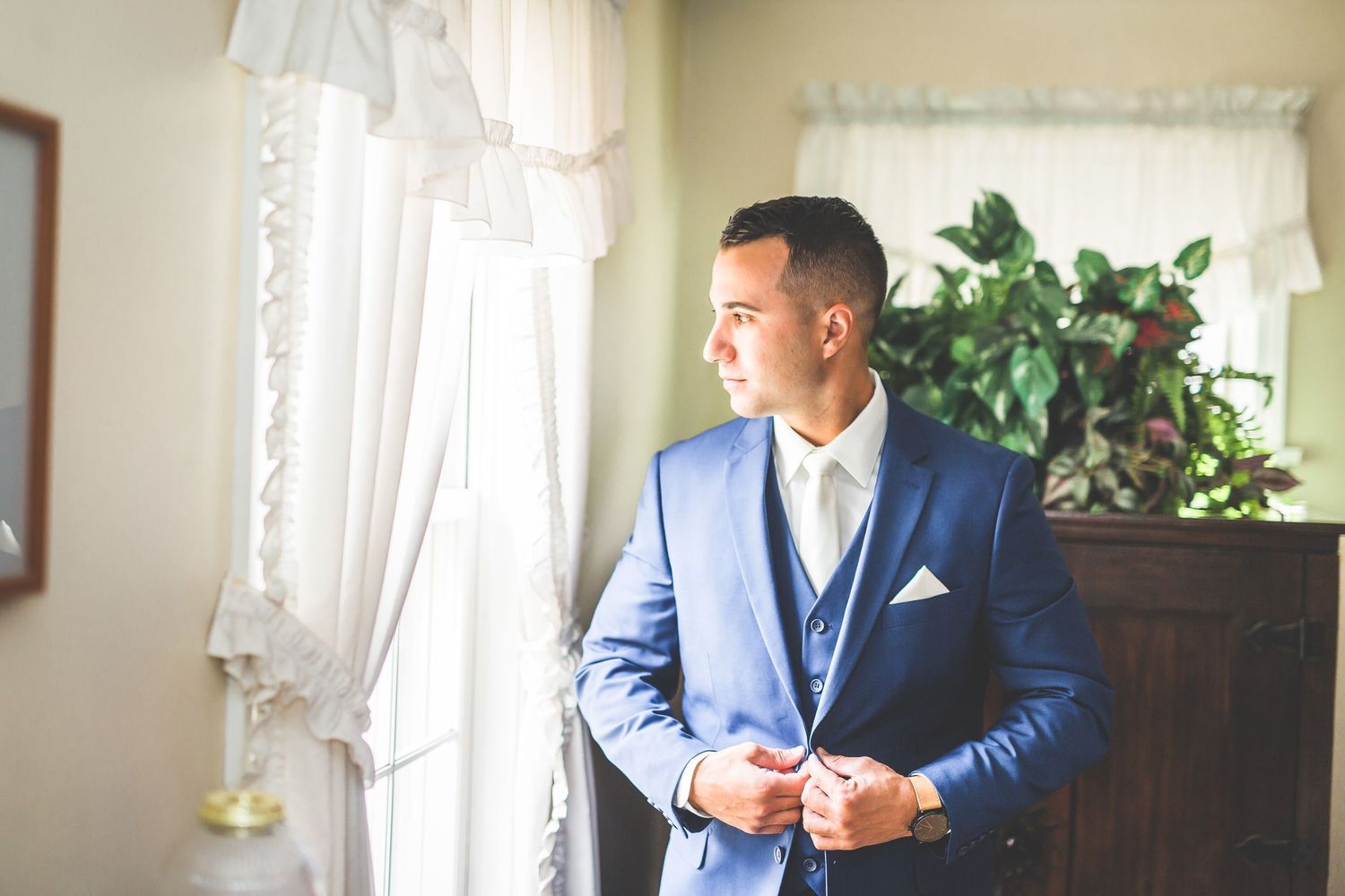 Getting ready scenes in a sunlit room with blue suit details.