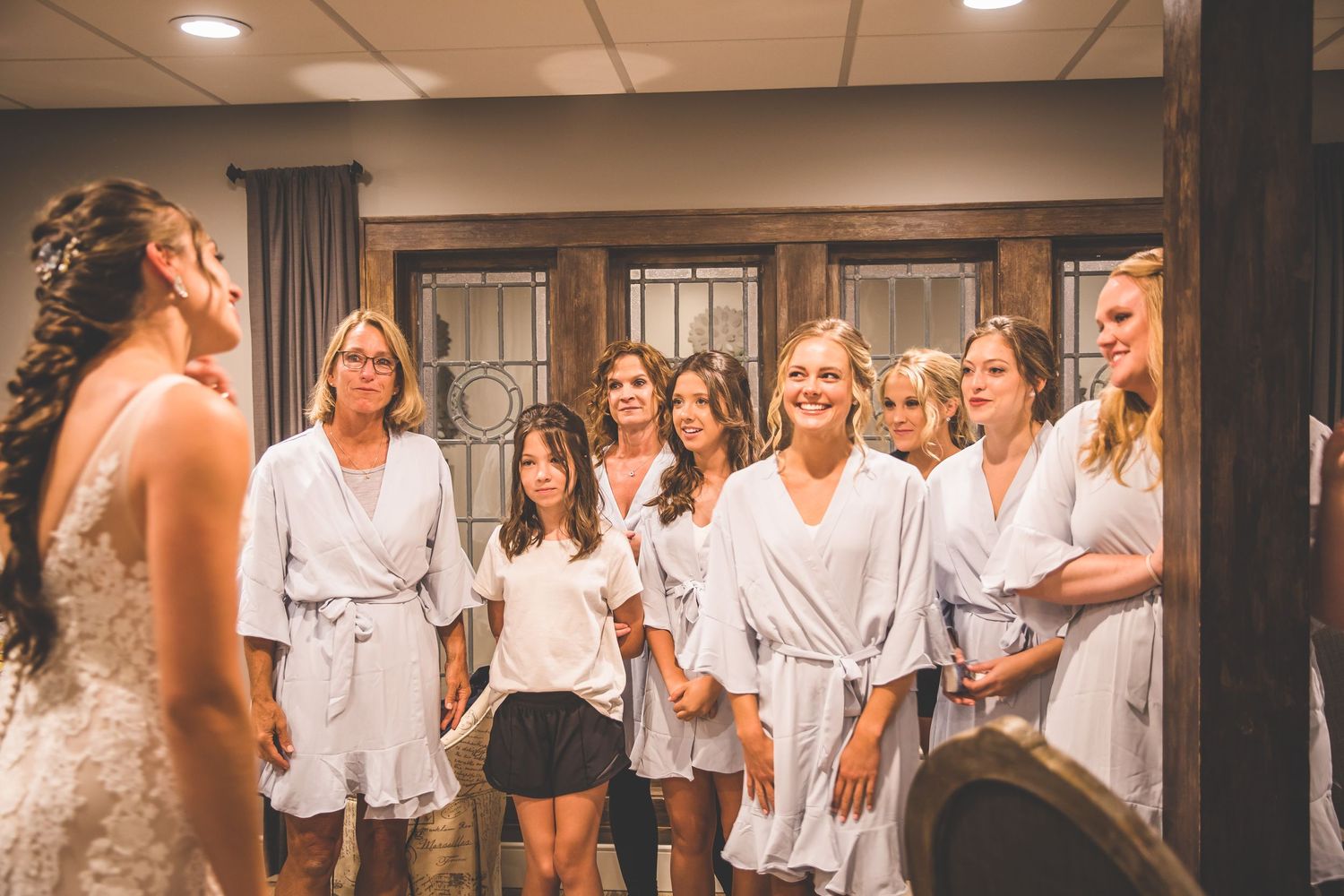 Wedding party members gathered in an indoor venue wearing coordinated outfits.