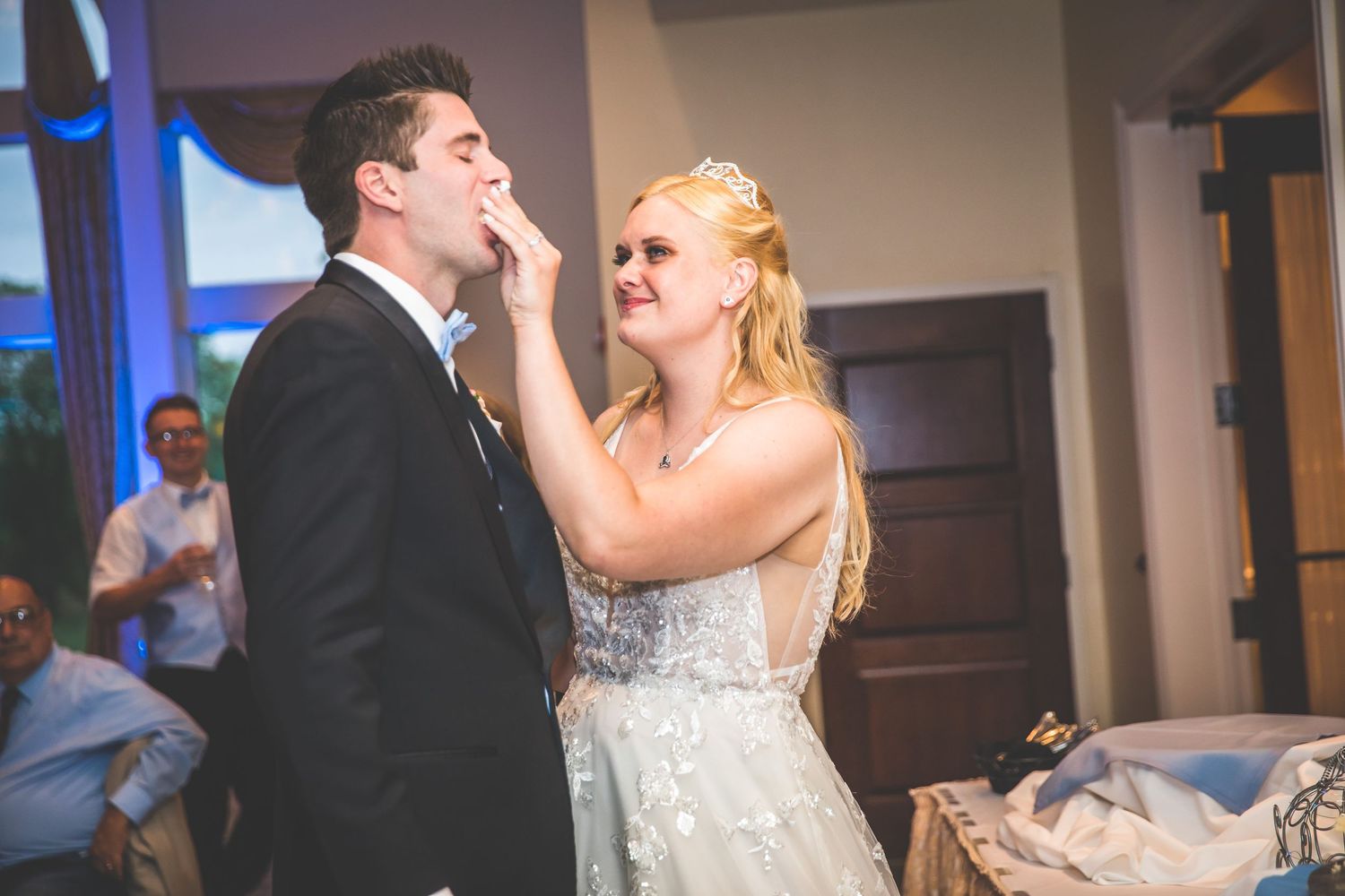 Newlyweds share an intimate moment during their first dance at an indoor wedding reception.