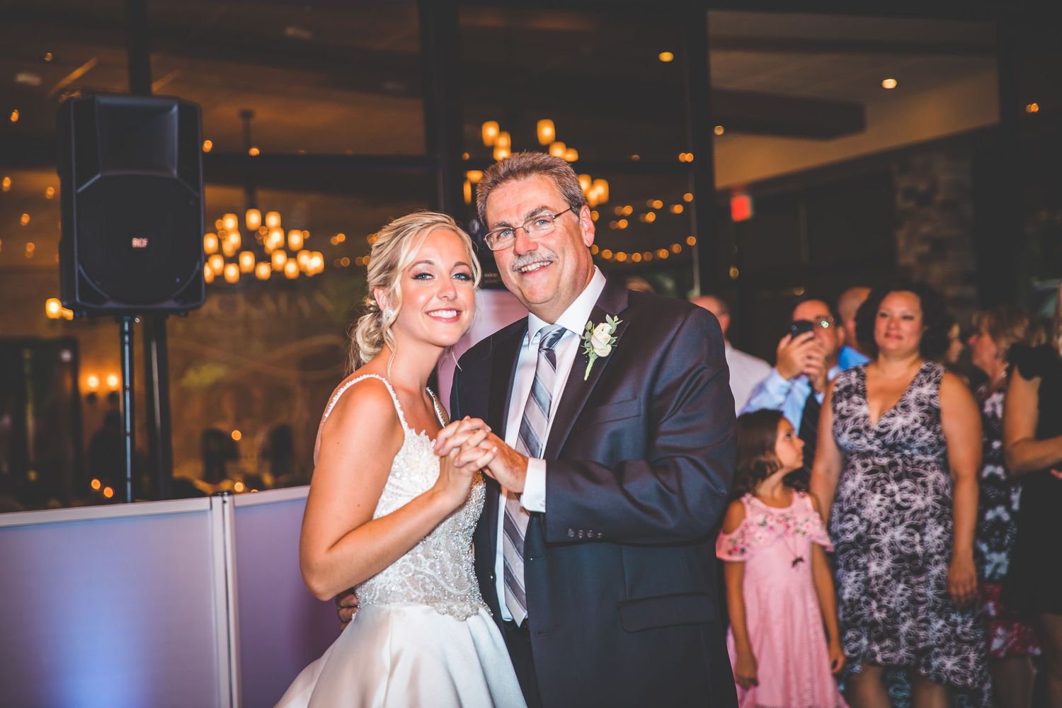 Wedding reception dance party with warm ambient lighting.