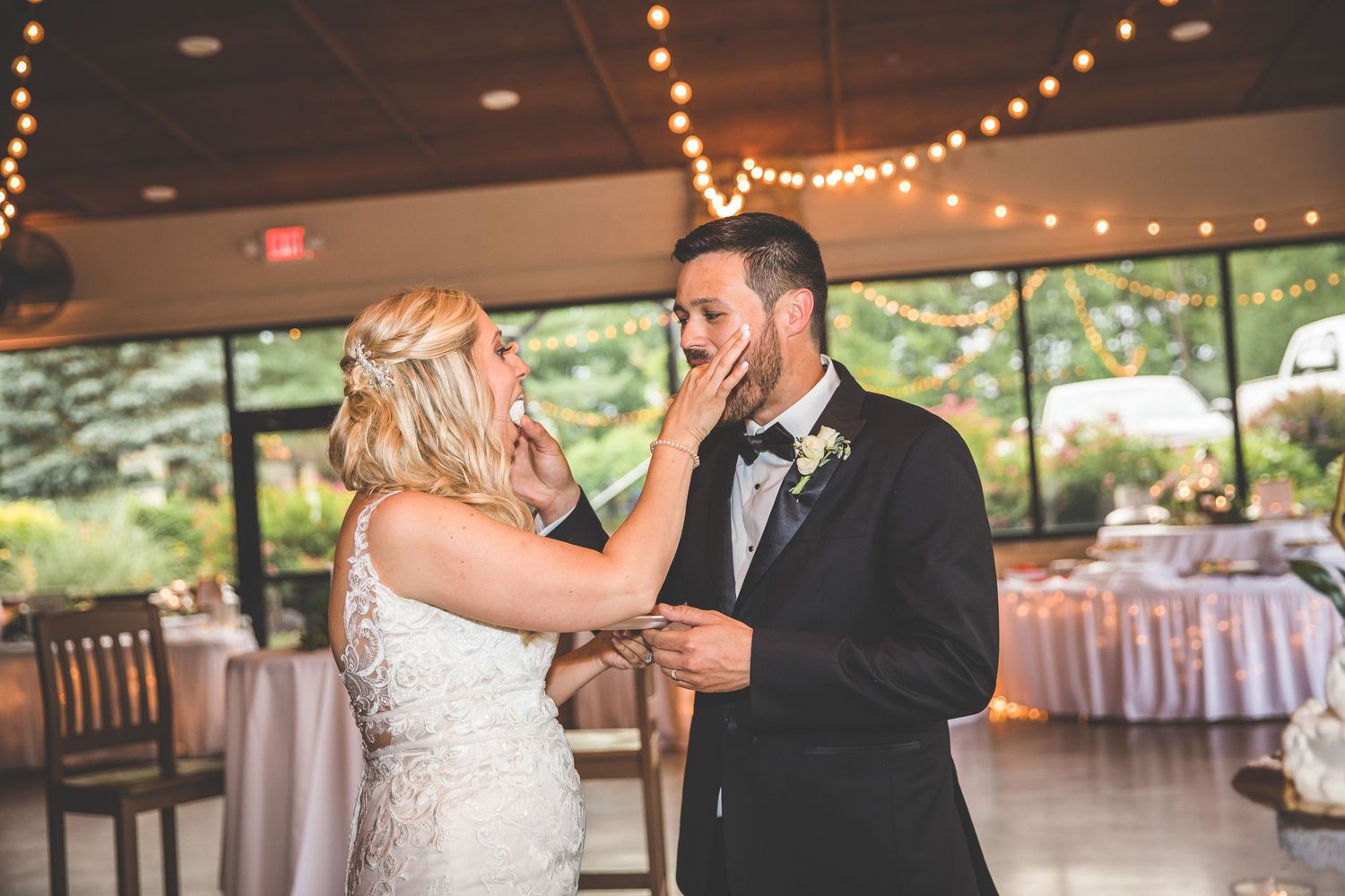 A couple sharing a playful moment during their wedding cake cutting ceremony.