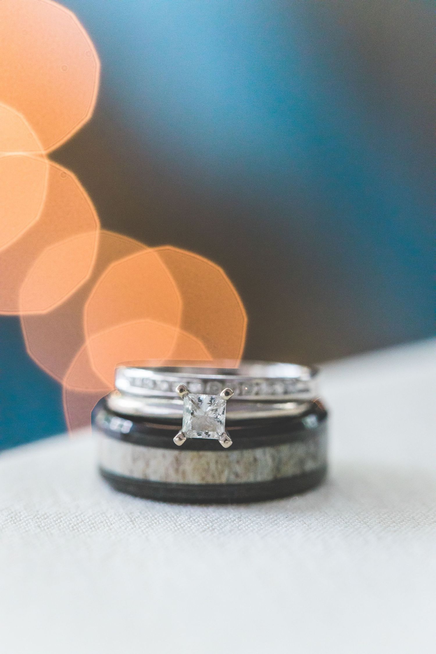 Wedding rings and bands displayed with soft bokeh lighting effects in the background.