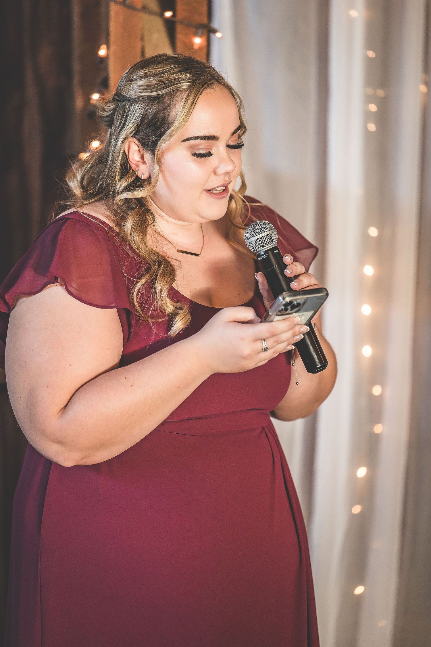 Person in burgundy dress enjoying a special moment at an elegant wedding reception.