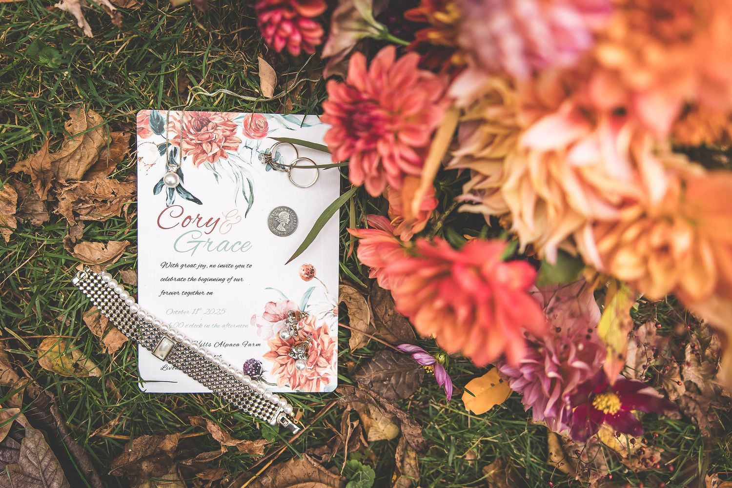 Close-up of coral and pink dahlias with wedding stationery details.