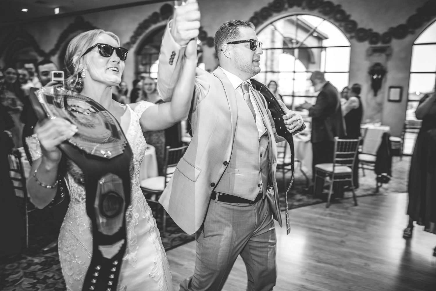 Black and white photo of a couple celebrating during their wedding reception.