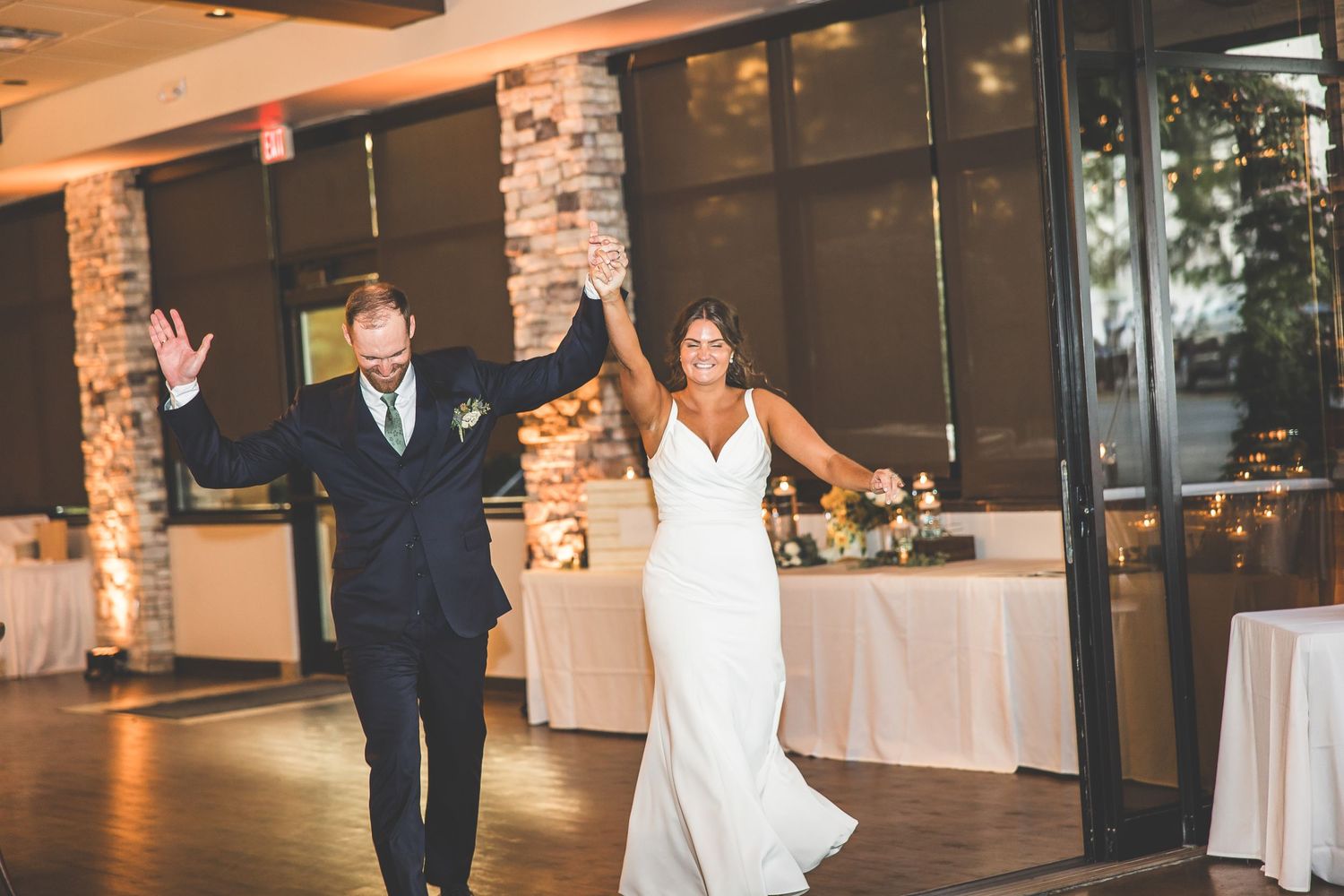 Wedding reception venue with string lights and rustic stone accents.
