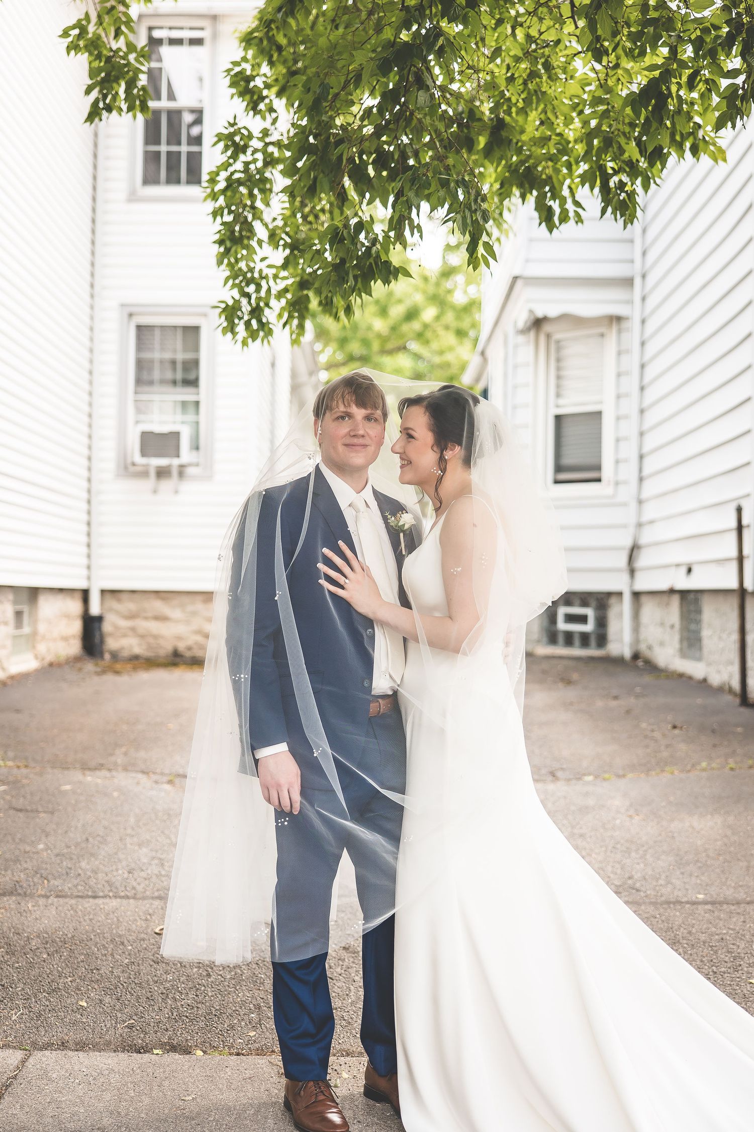 Flowing white wedding dress creates movement in outdoor portrait session.