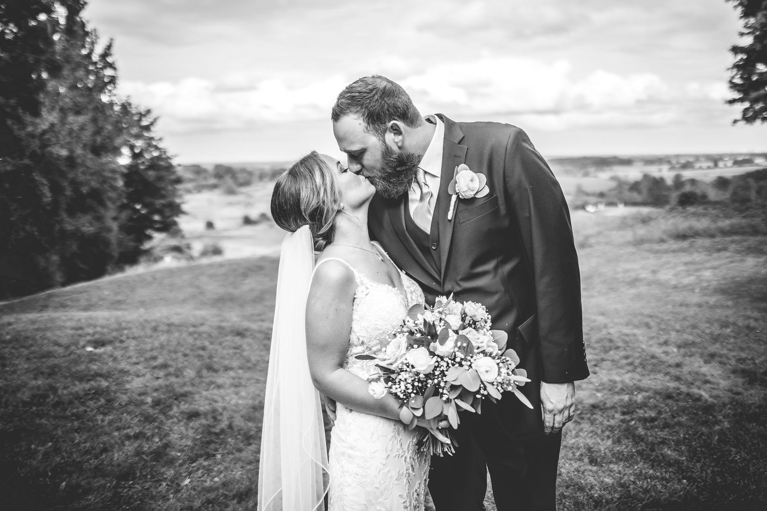 Black and white wedding portraits showing intimate moments between newlyweds in an outdoor setting.