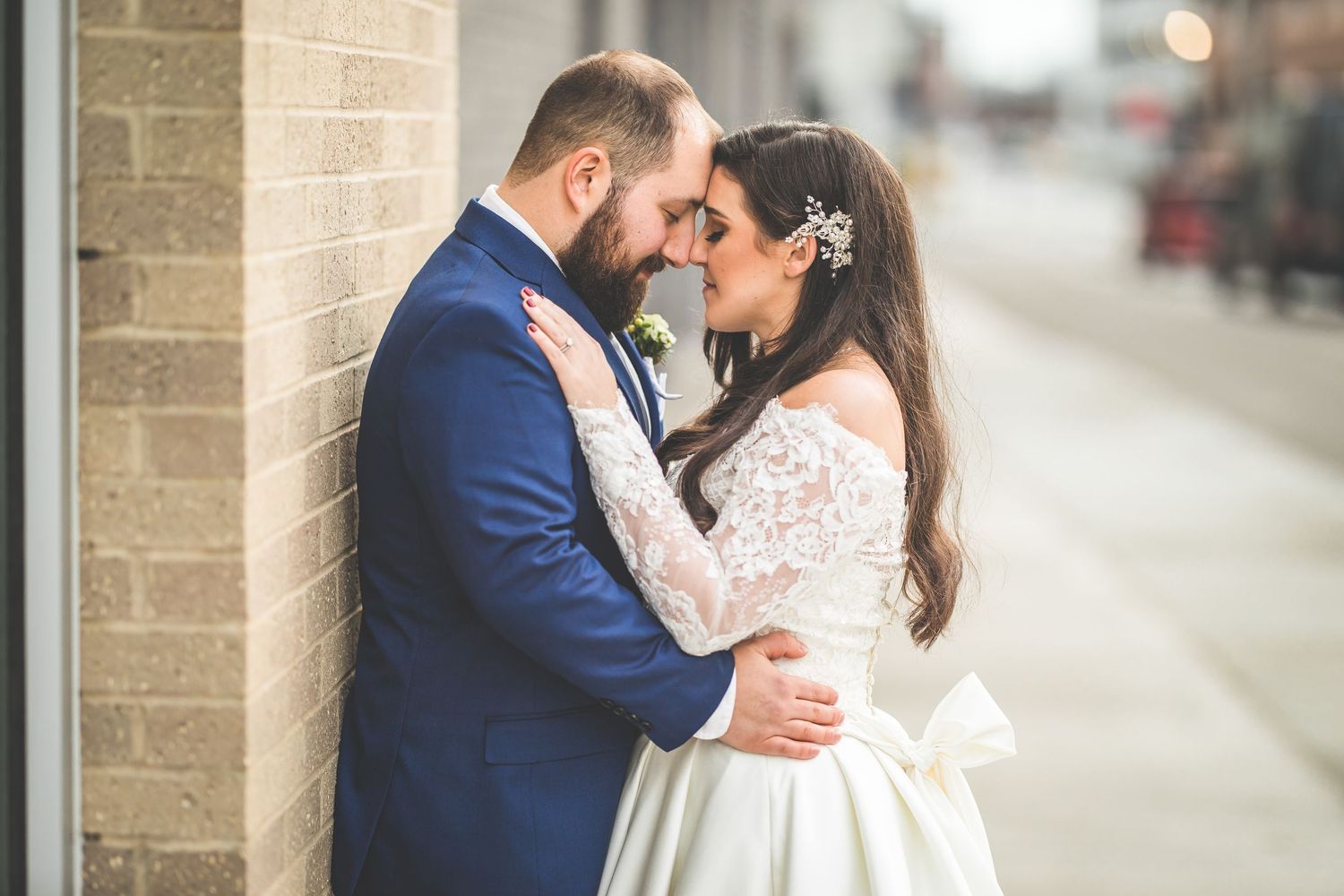 Intimate wedding portrait against a stone wall background.
