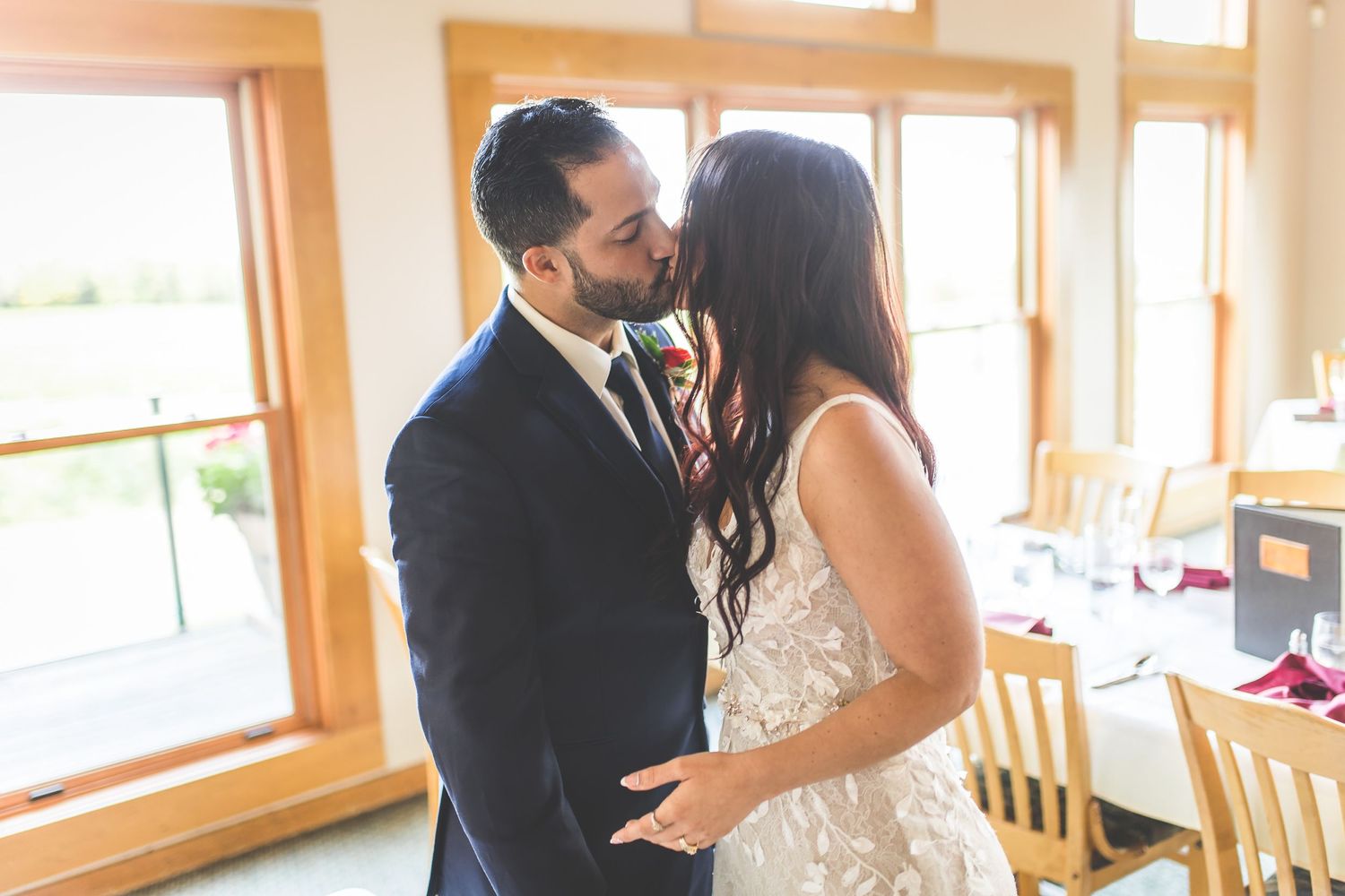 Couple enjoying an intimate moment in a rustic venue with natural lighting.