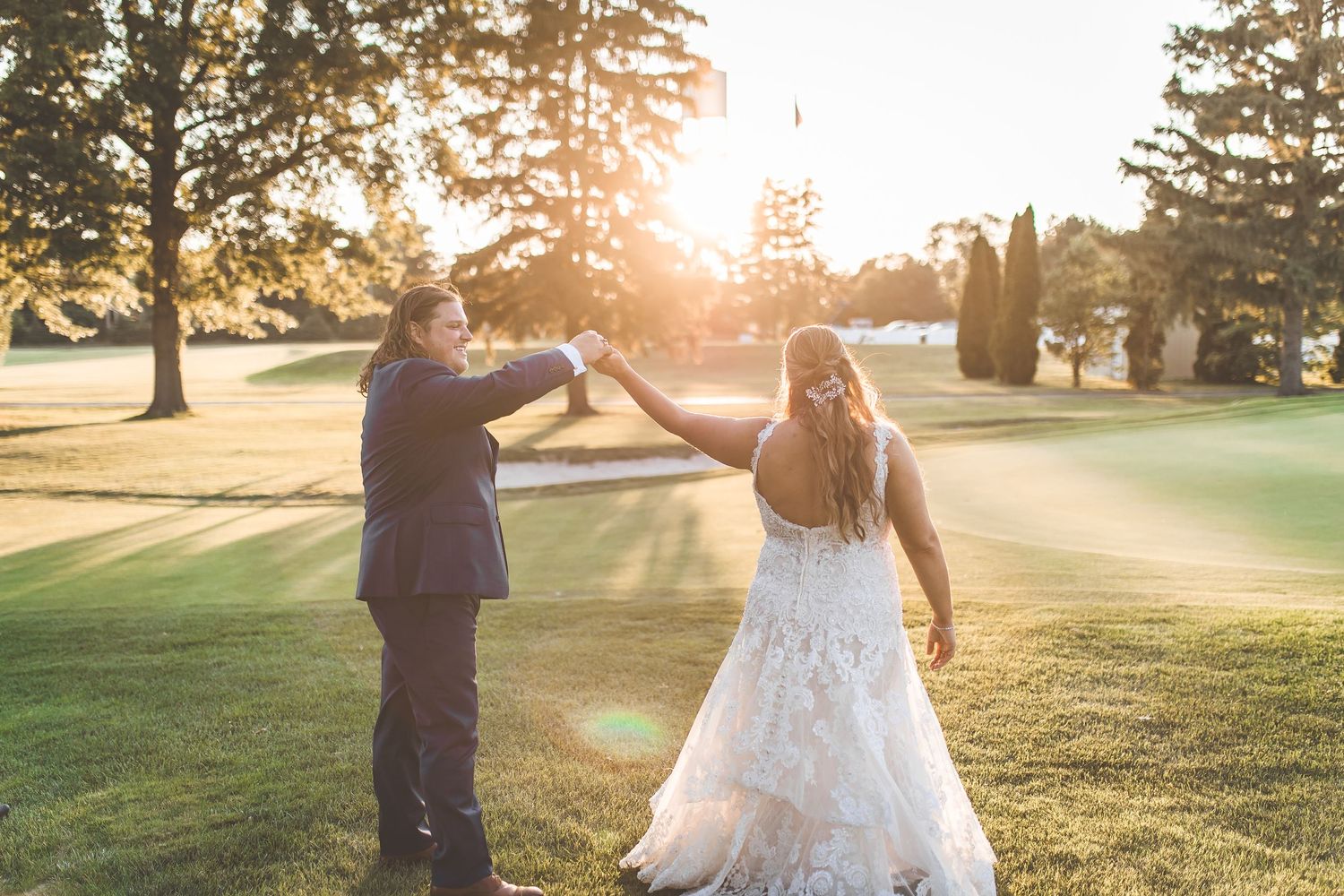 Romantic sunset wedding photo session on a golf course with golden hour lighting.