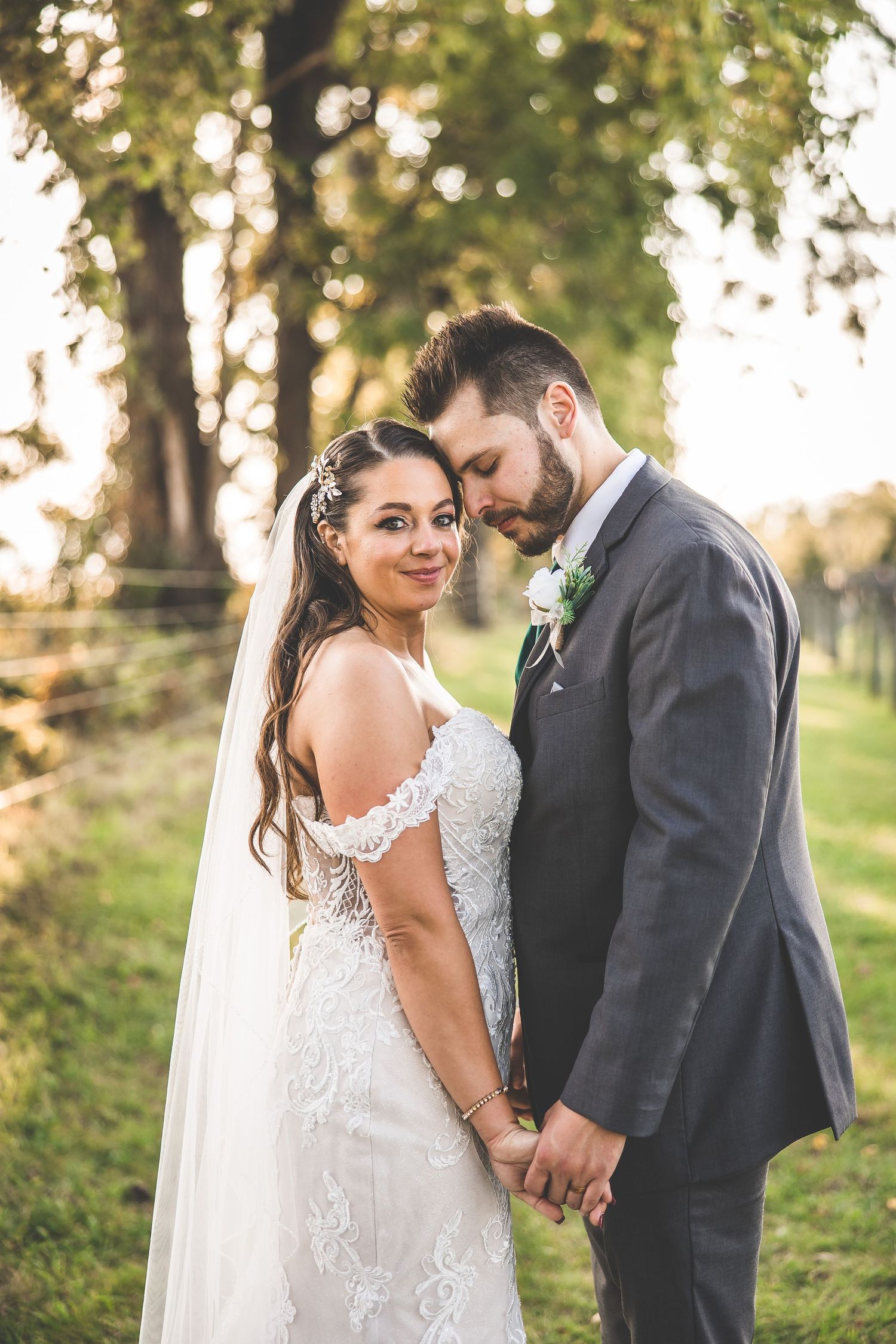 Romantic wedding portraits captured in golden hour lighting among trees.
