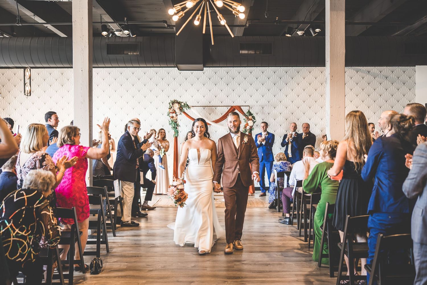 Wedding reception venue with guests seated at round tables and dance floor.