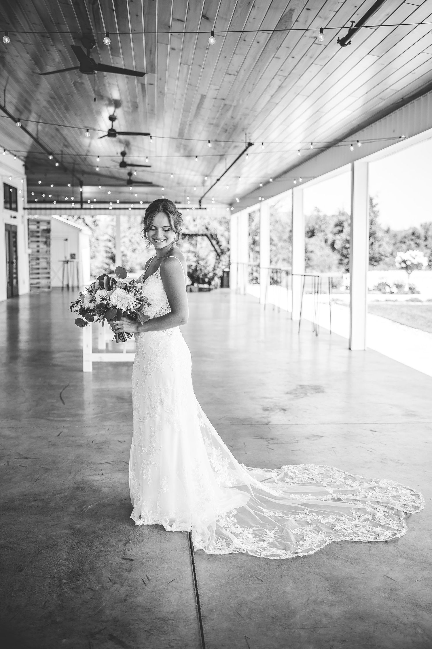 Dramatic black and white photo showcasing a wedding dress train in an open venue.