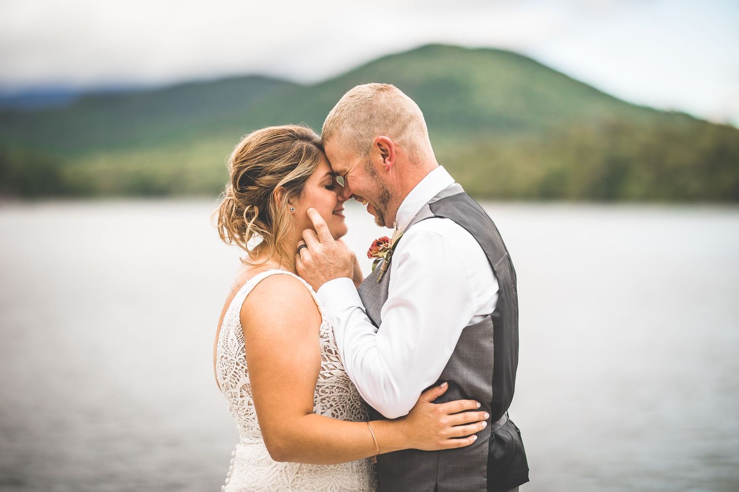 Intimate wedding couple portraits captured against a scenic mountain lake backdrop.