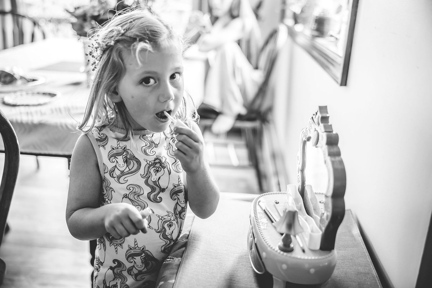 A young child plays during wedding preparations in a candid black and white photo.