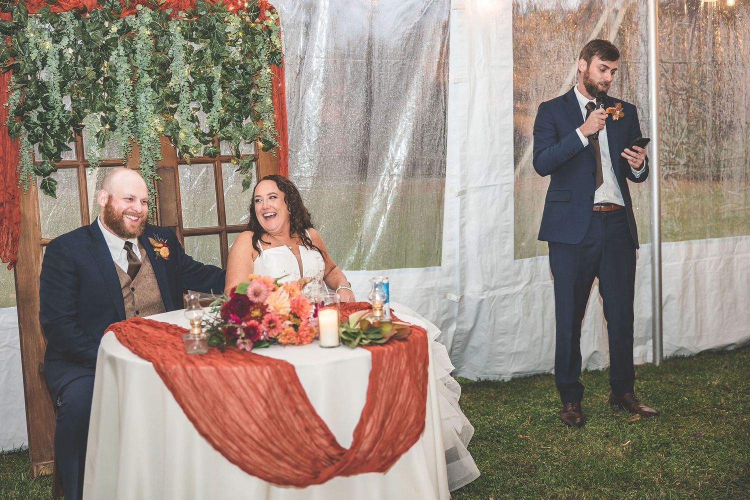 Wedding reception venue with burgundy accents and white draping creating romantic ambiance.