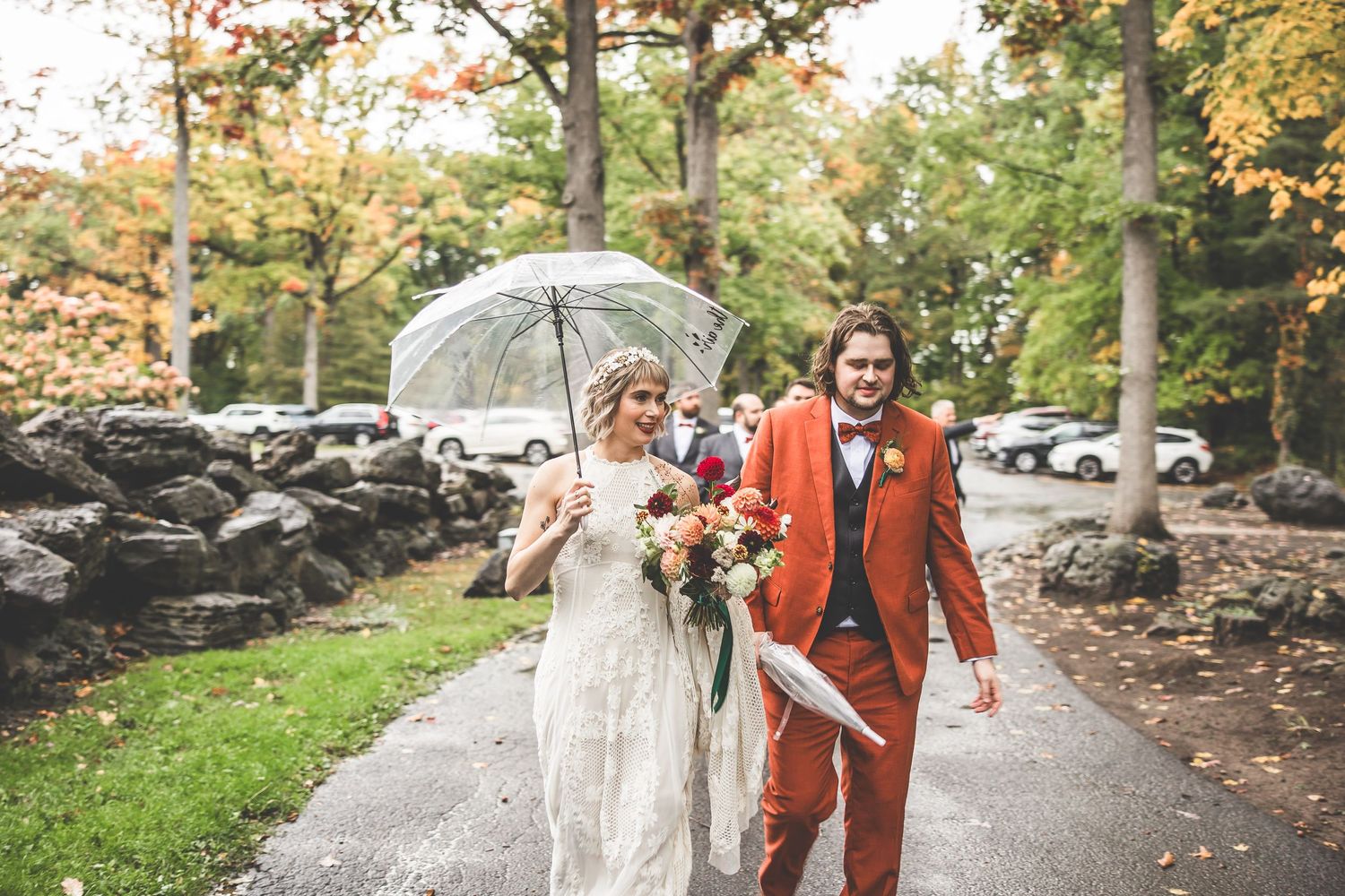 Outdoor autumn wedding photos with fall foliage and stone pathway backdrop.