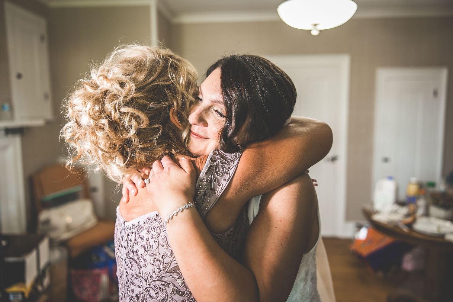 An emotional moment between two people during wedding preparations.