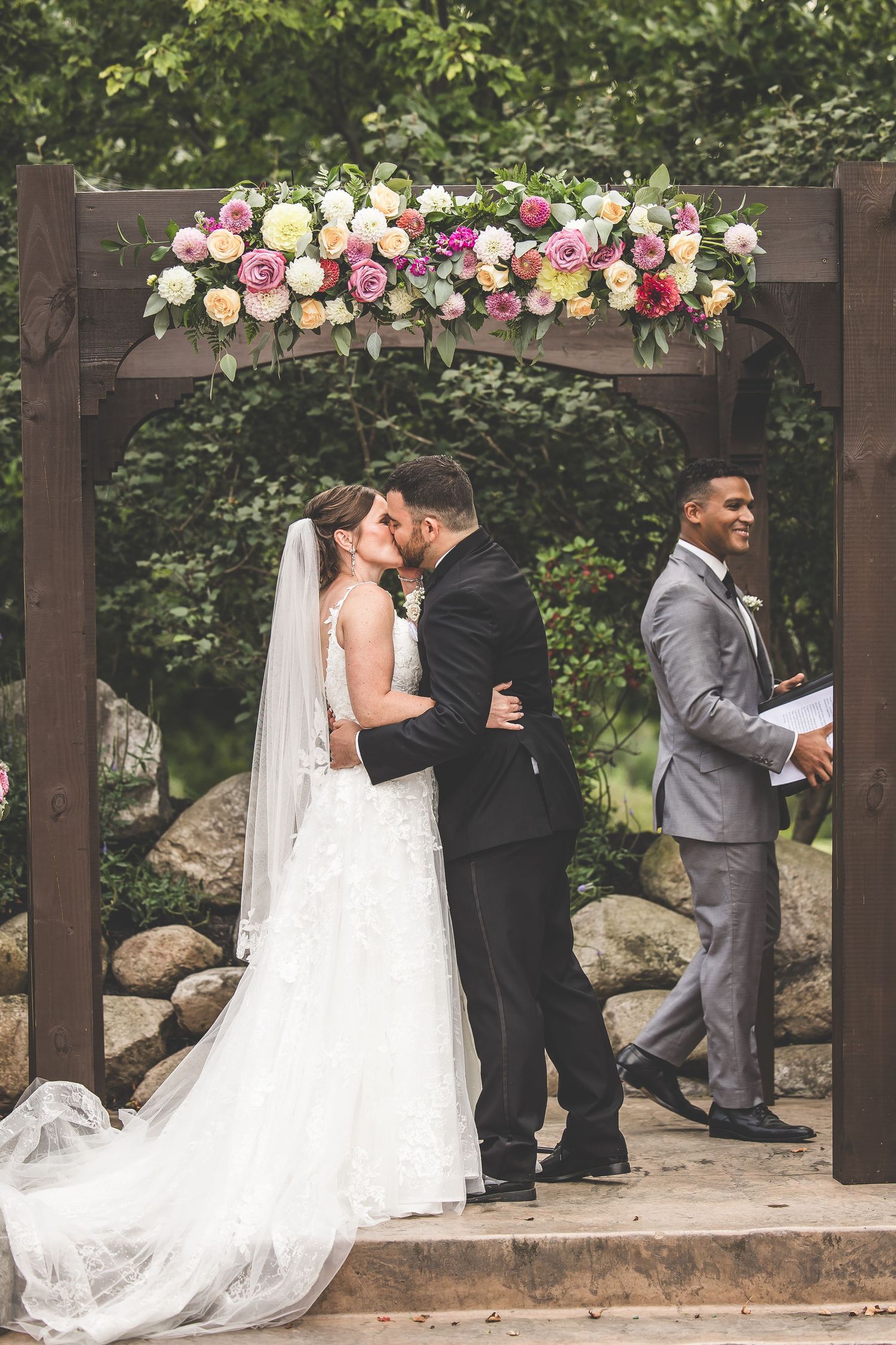Wedding ceremony sequence showing special moments under floral-decorated wooden pergola.