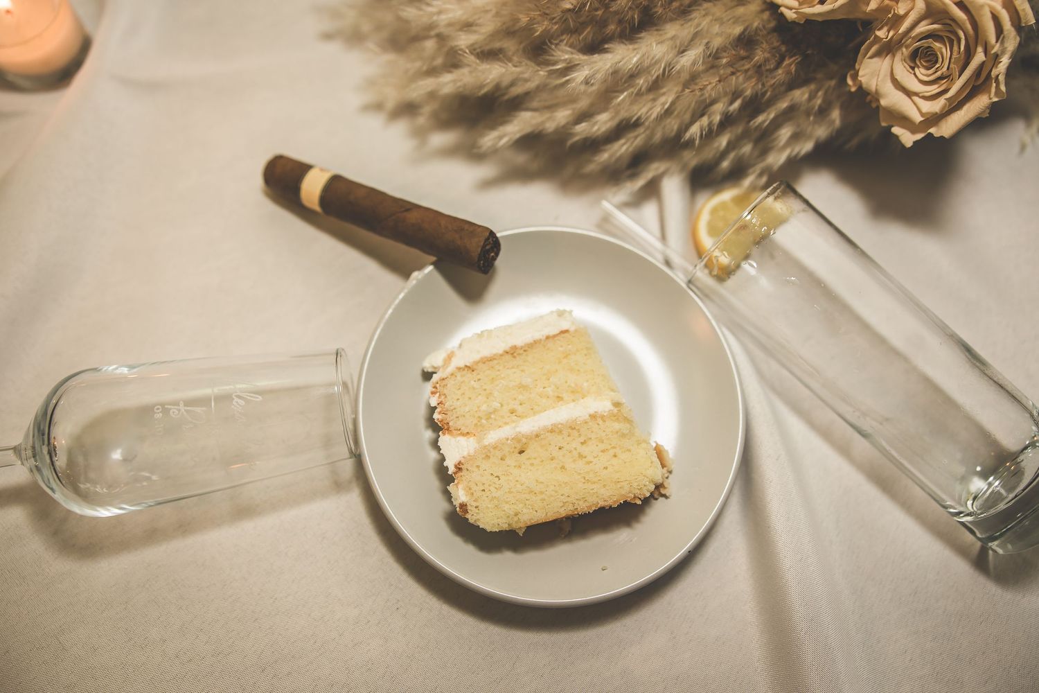 Elegant wedding cake slices and dessert plates on white tablecloth.