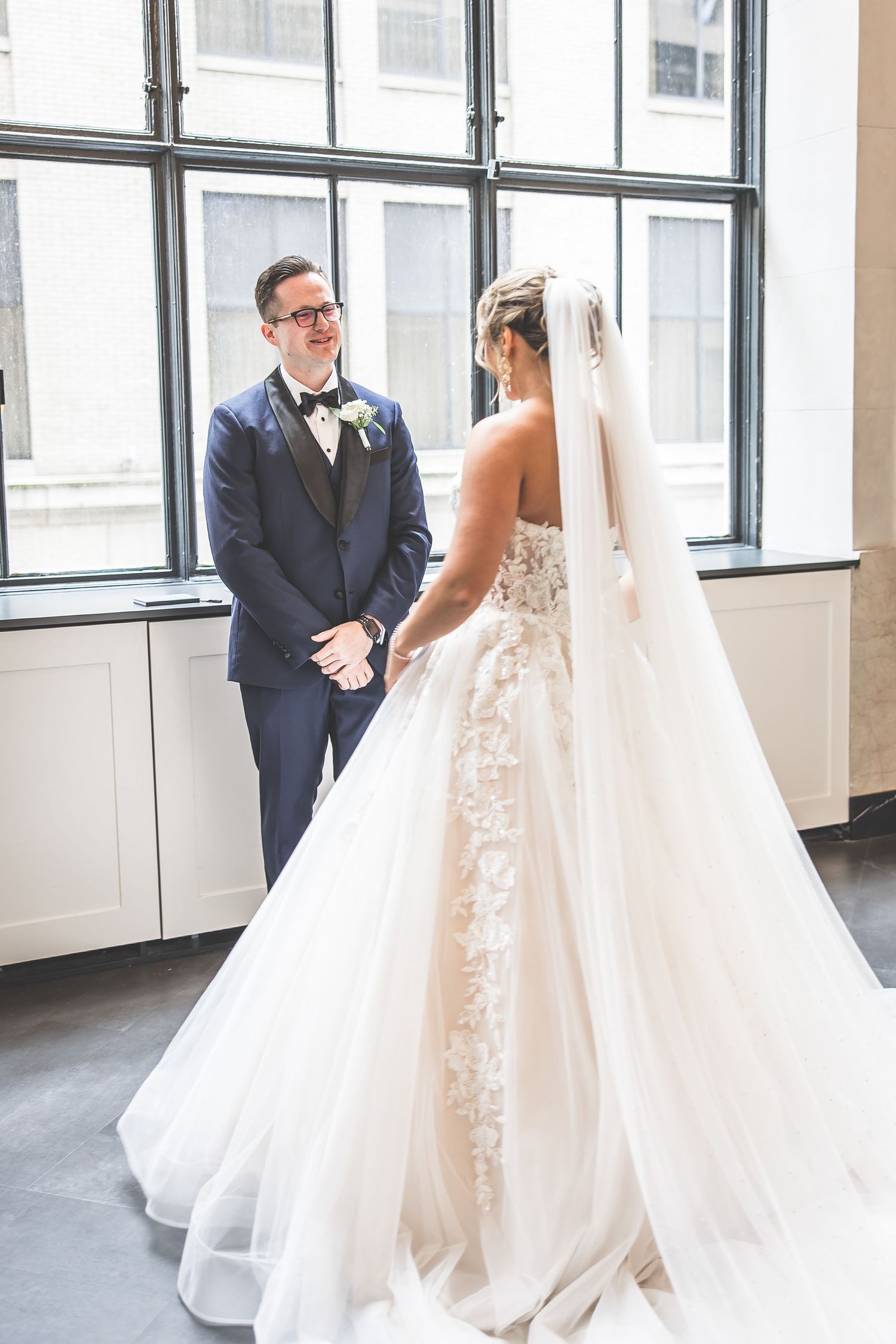 Romantic first look between couple in an urban loft setting with natural light.
