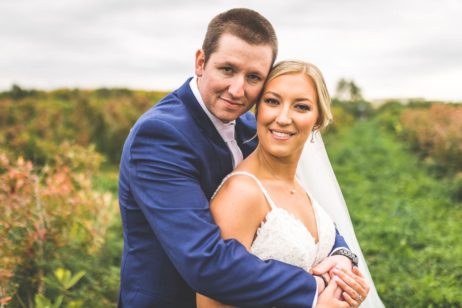 Wedding couple shares intimate moments in a field during golden hour photography session.