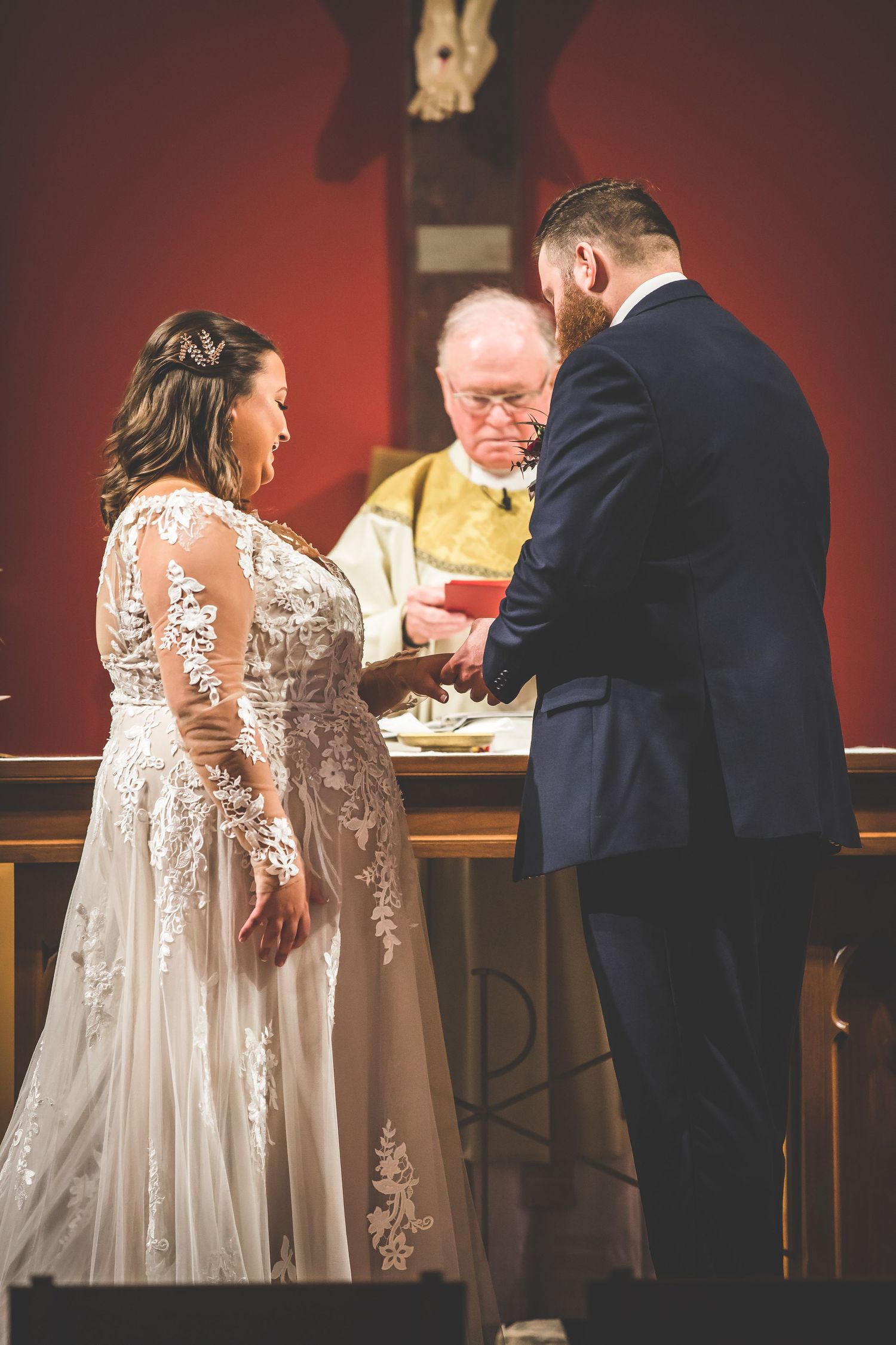 Wedding couple signing documents at a wooden table during their ceremony.