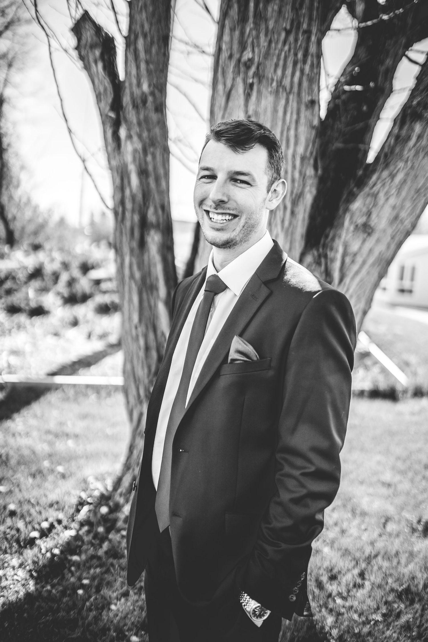 Candid outdoor portraits in formal attire among tall trees.