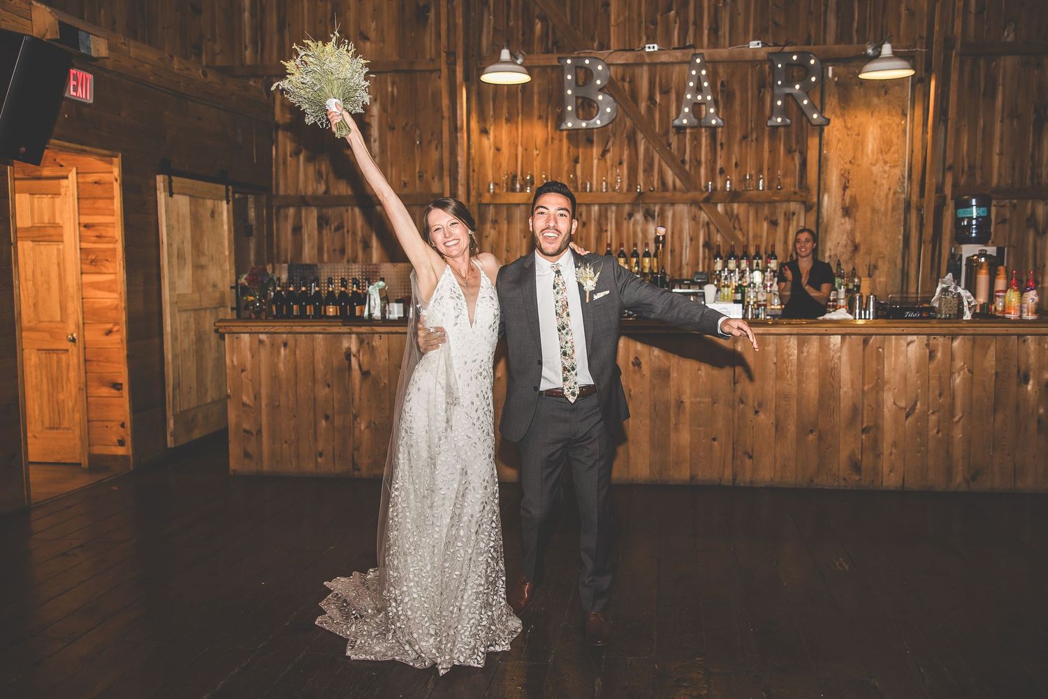 Wedding reception setup in a rustic wooden barn with string lights and elegant decor.