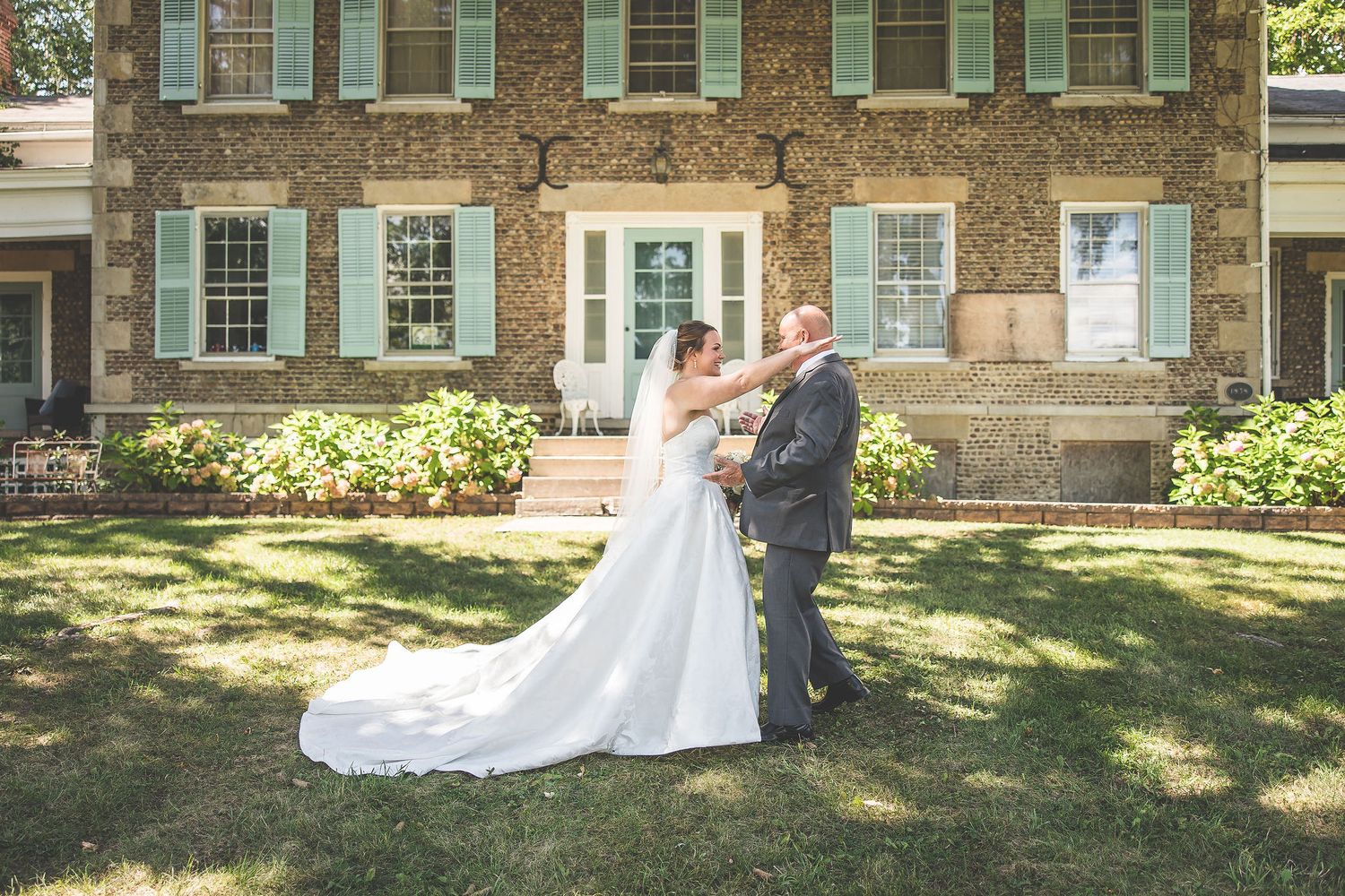Elegant wedding photos taken against the backdrop of a classic brick colonial building.