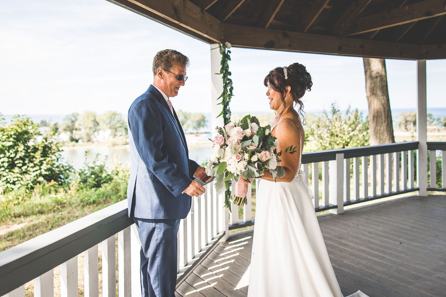 Romantic first look moment between newlyweds on a rustic covered porch.