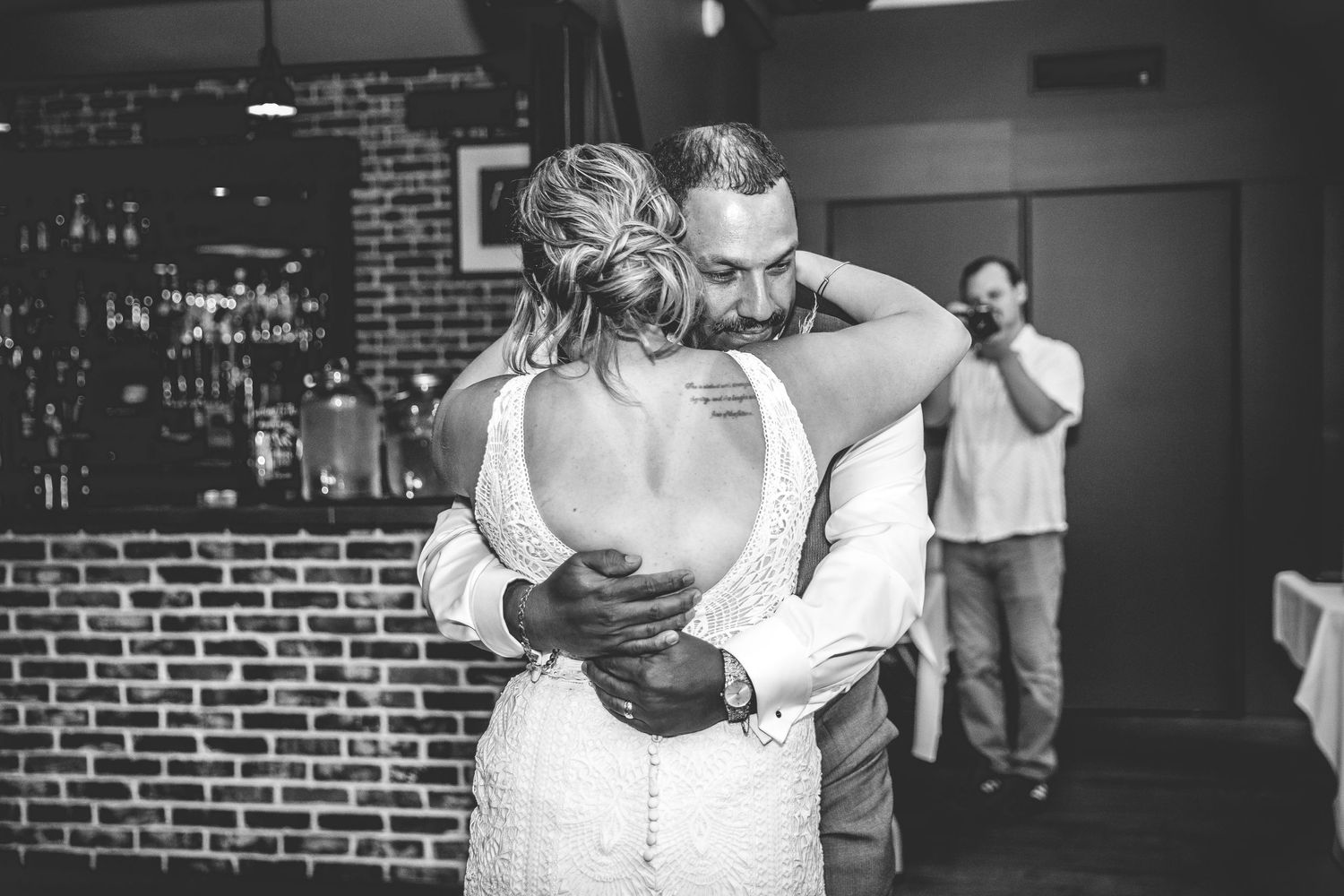 Wedding reception dance floor filled with guests celebrating and dancing at a rustic brick venue.