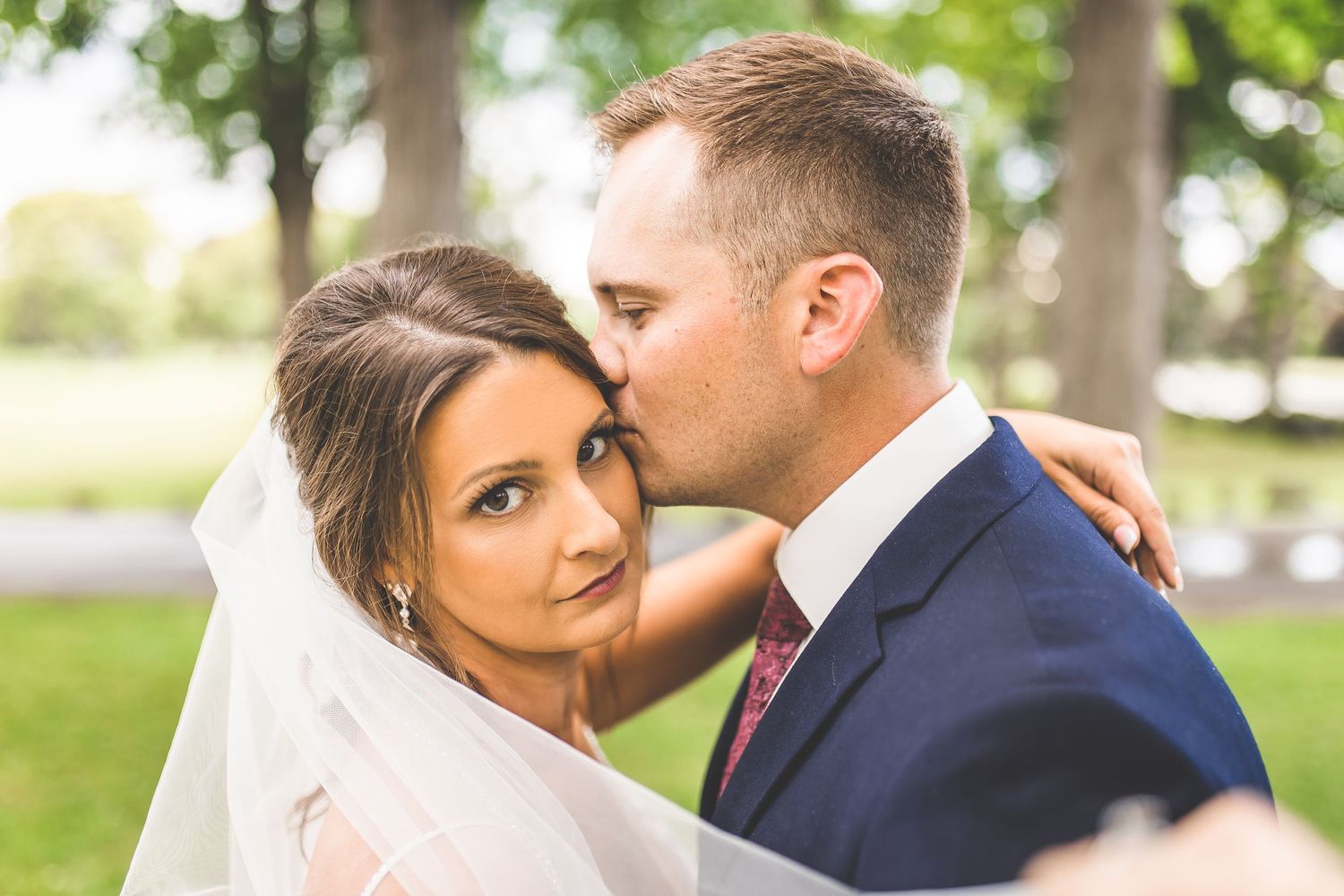 Close-up wedding portraits showing tender moments between couple outdoors.