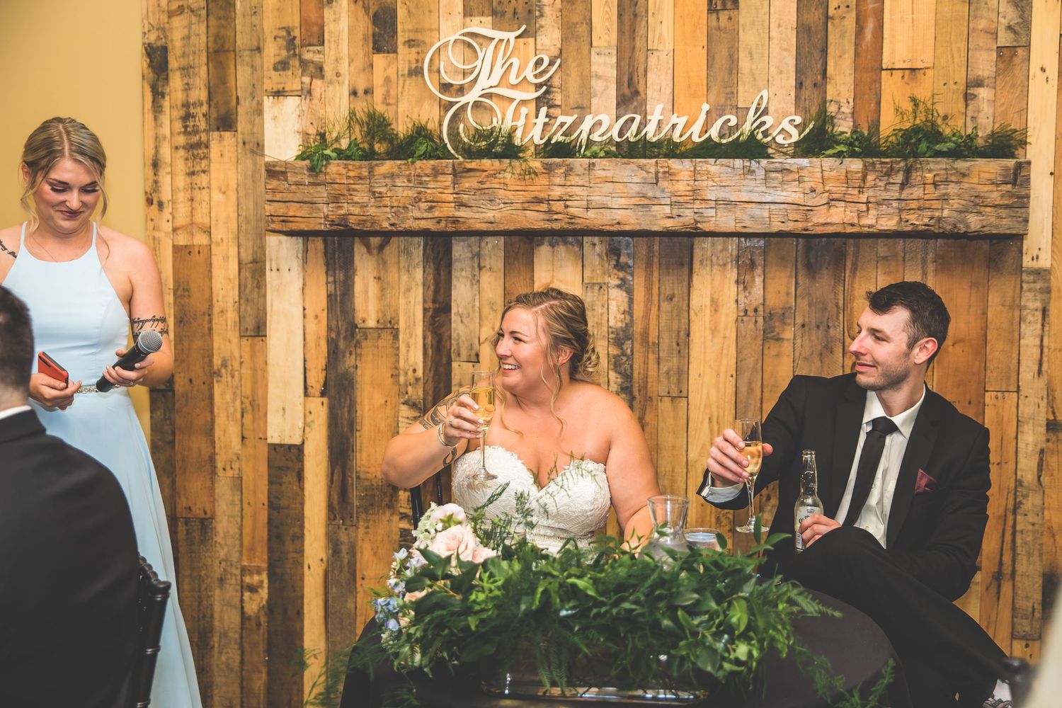 Wedding reception venue decorated with rustic wooden walls and string lights.