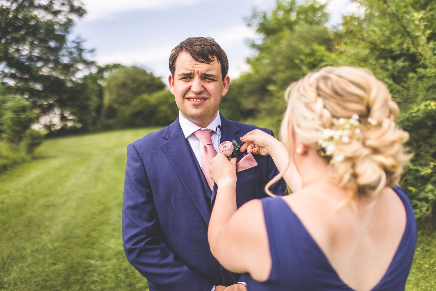 Romantic first look moment between couple on a sunny hillside.