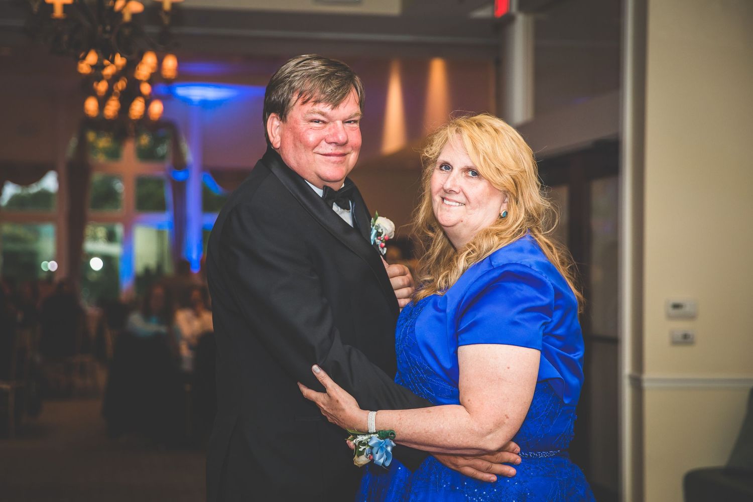 Formal dance moment captured during wedding reception with dramatic lighting and decor.
