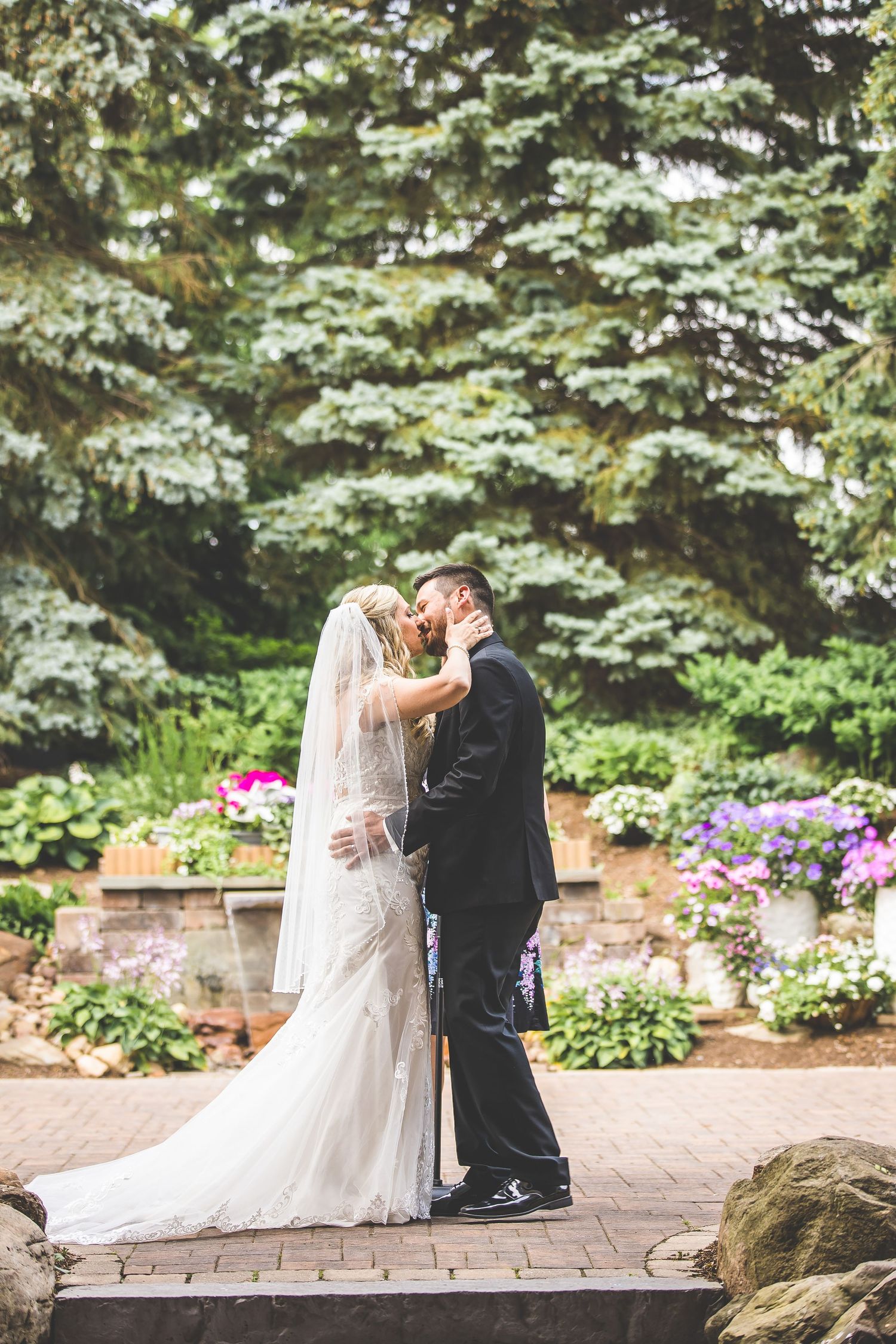 Series of romantic wedding ceremony moments on a brick patio surrounded by evergreen trees.