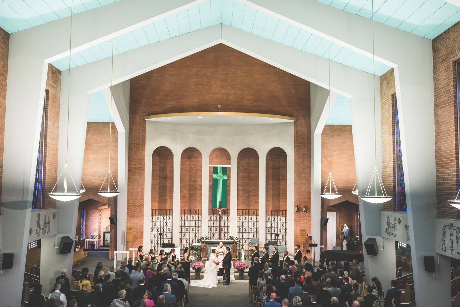 Interior view of a modern church sanctuary with exposed brick walls and white columns.
