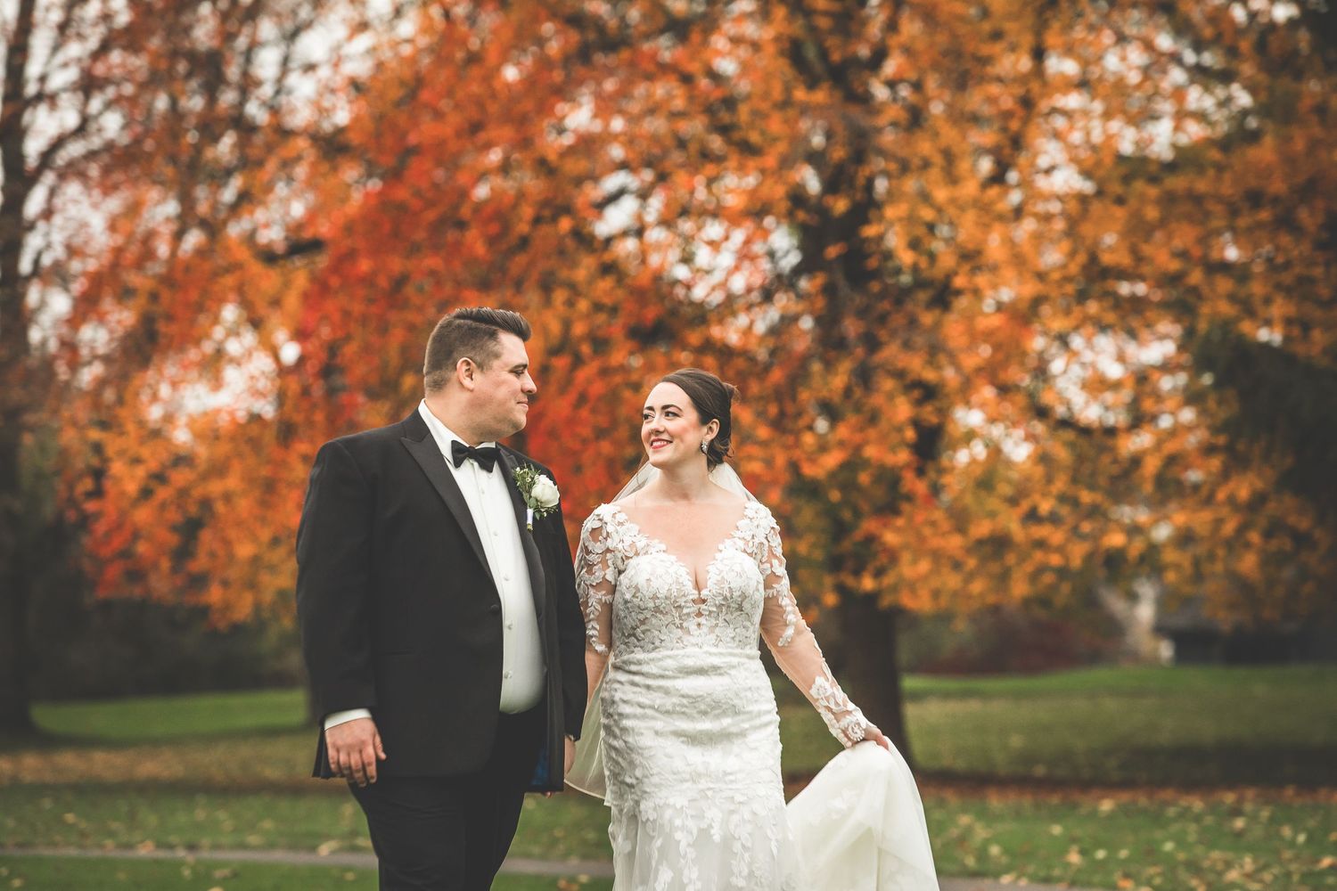 Romantic wedding portraits captured against a backdrop of bright orange fall foliage.
