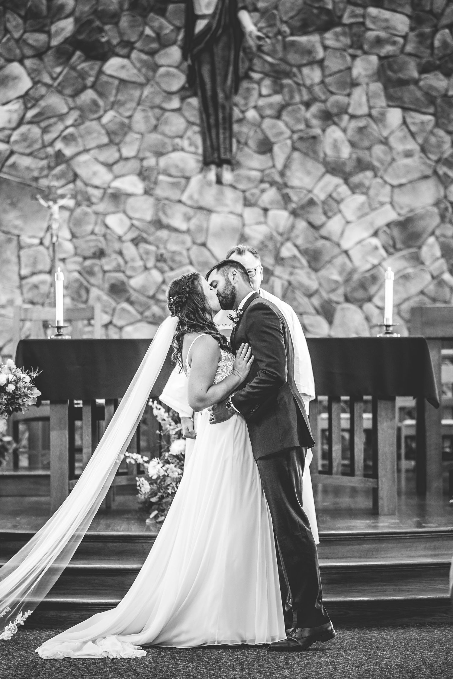 Black and white photos of wedding ceremony moments against textured stone wall backdrop.