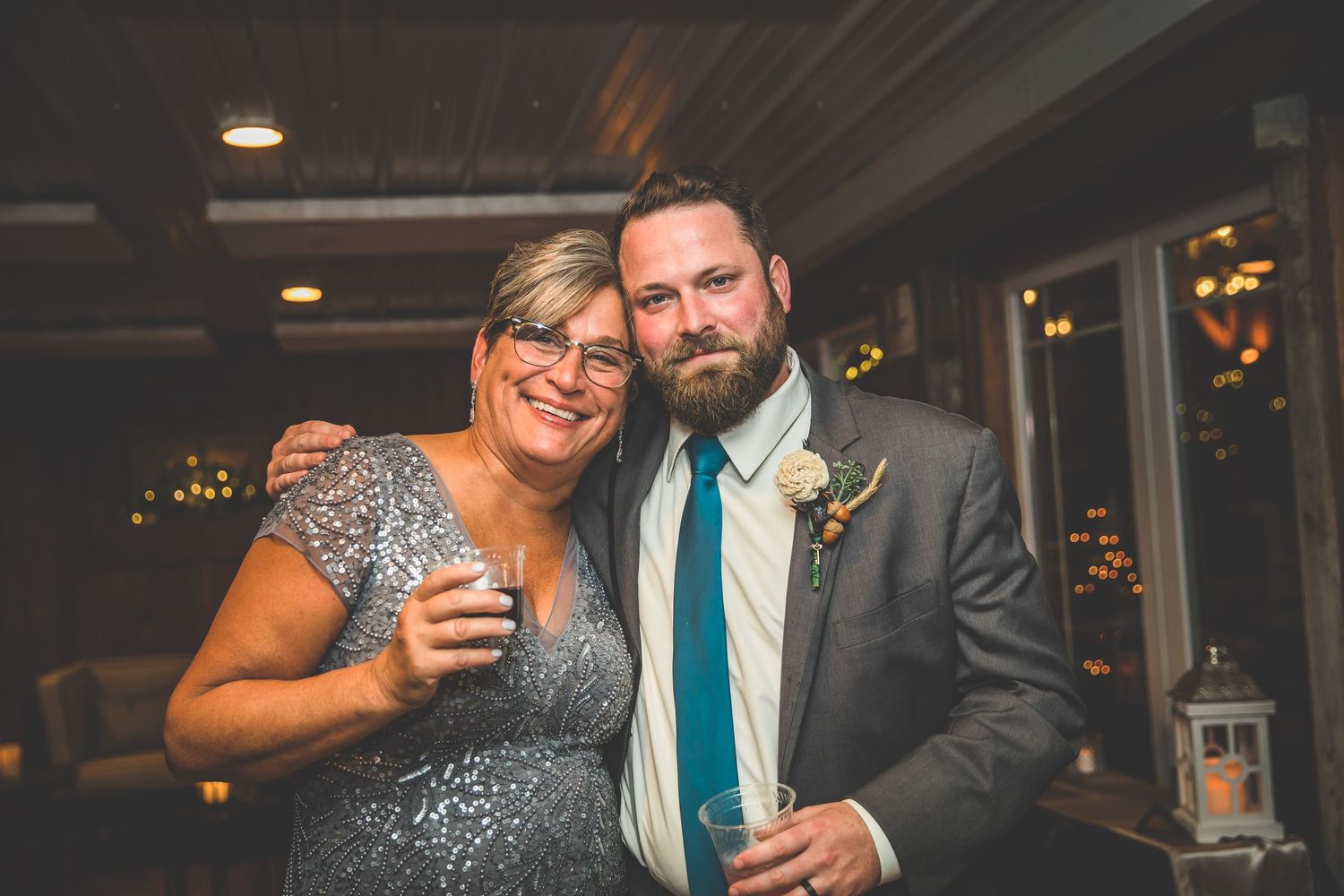 Wedding reception scene with couple dancing under warm indoor lighting.